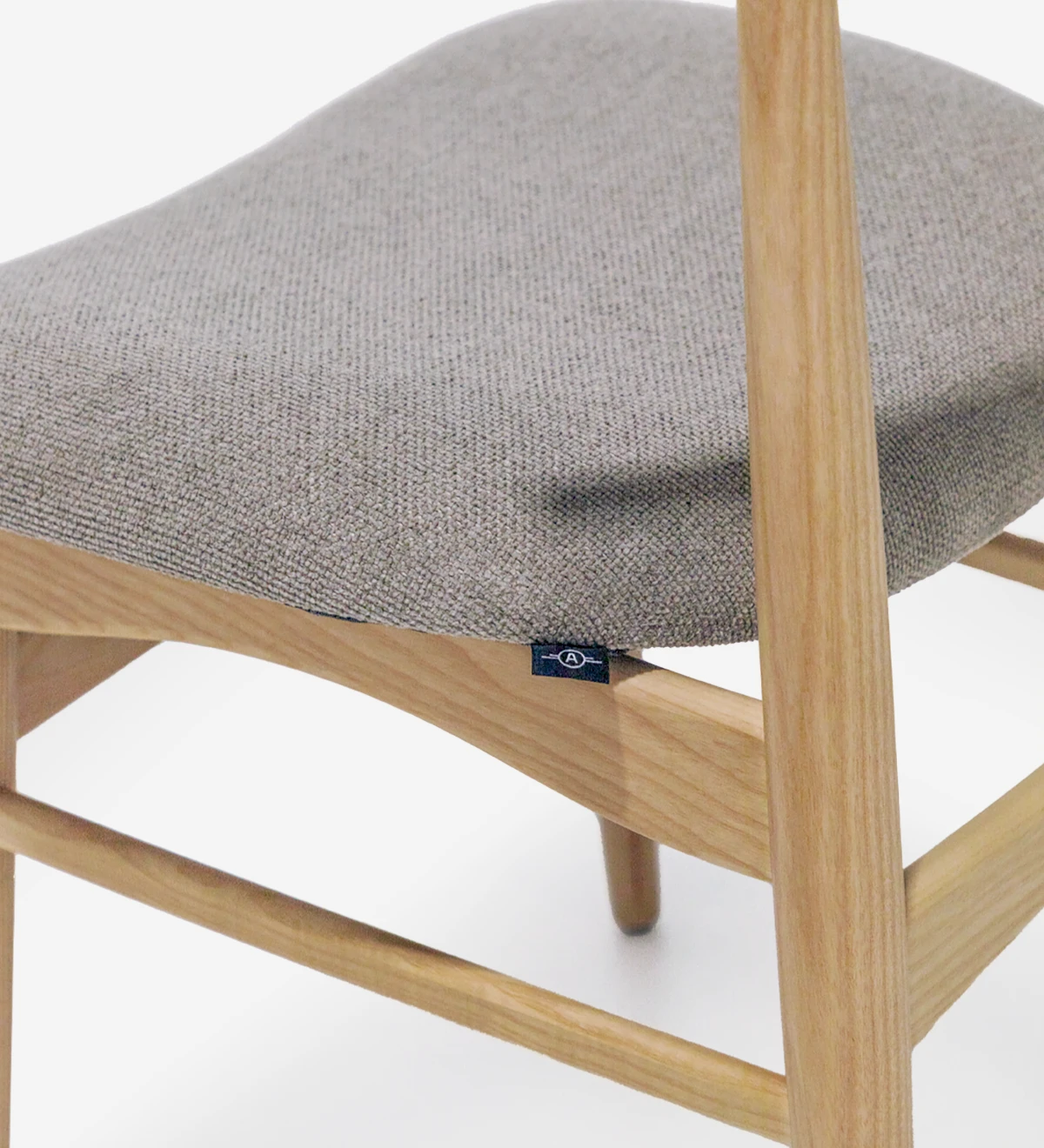 Chaise en bois de frêne, couleur naturelle, avec assise recouverte de tissu.