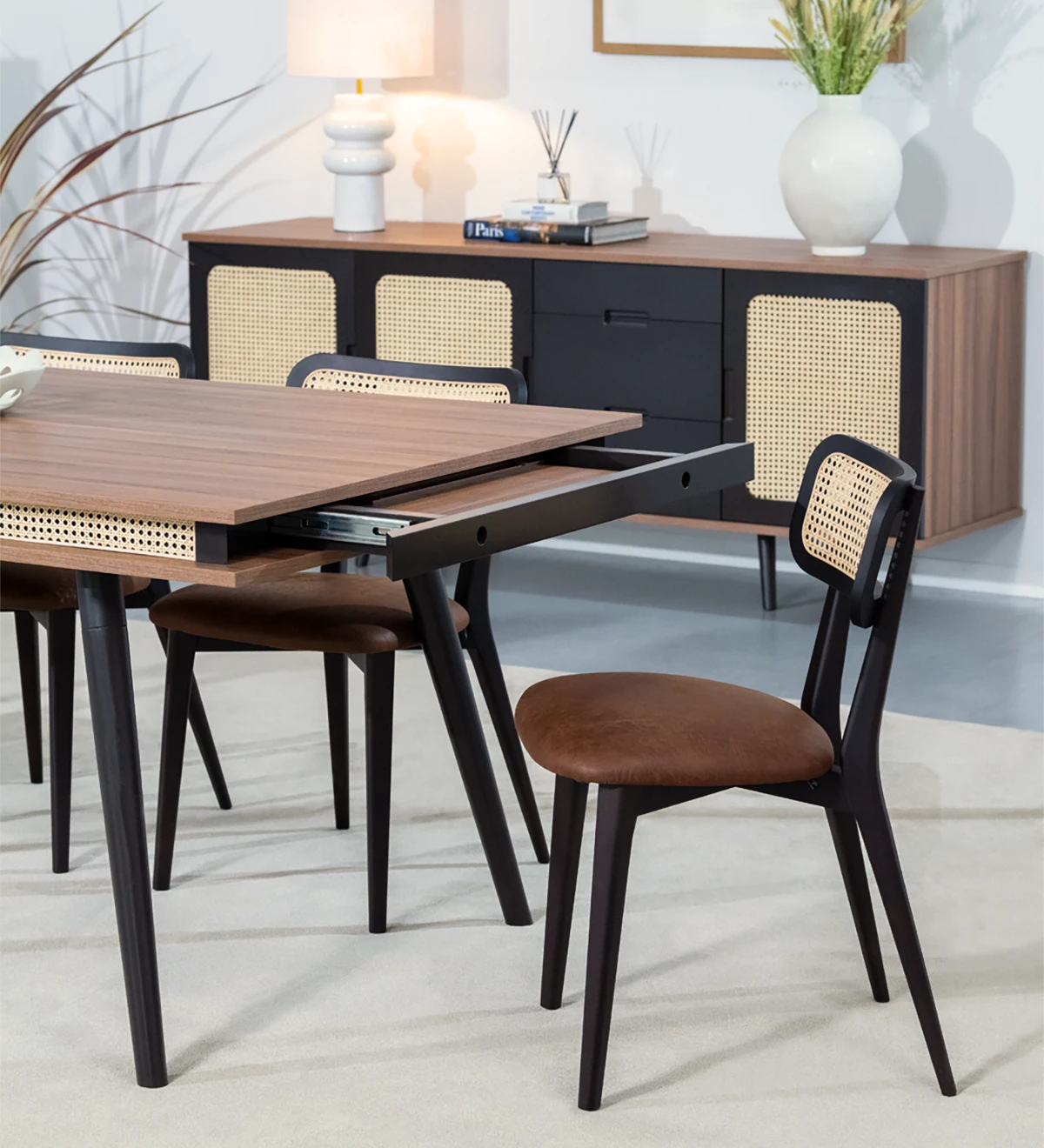 Mesa de comedor rectangular extensible con tablero de nogal y patas lacadas en marrón oscuro.