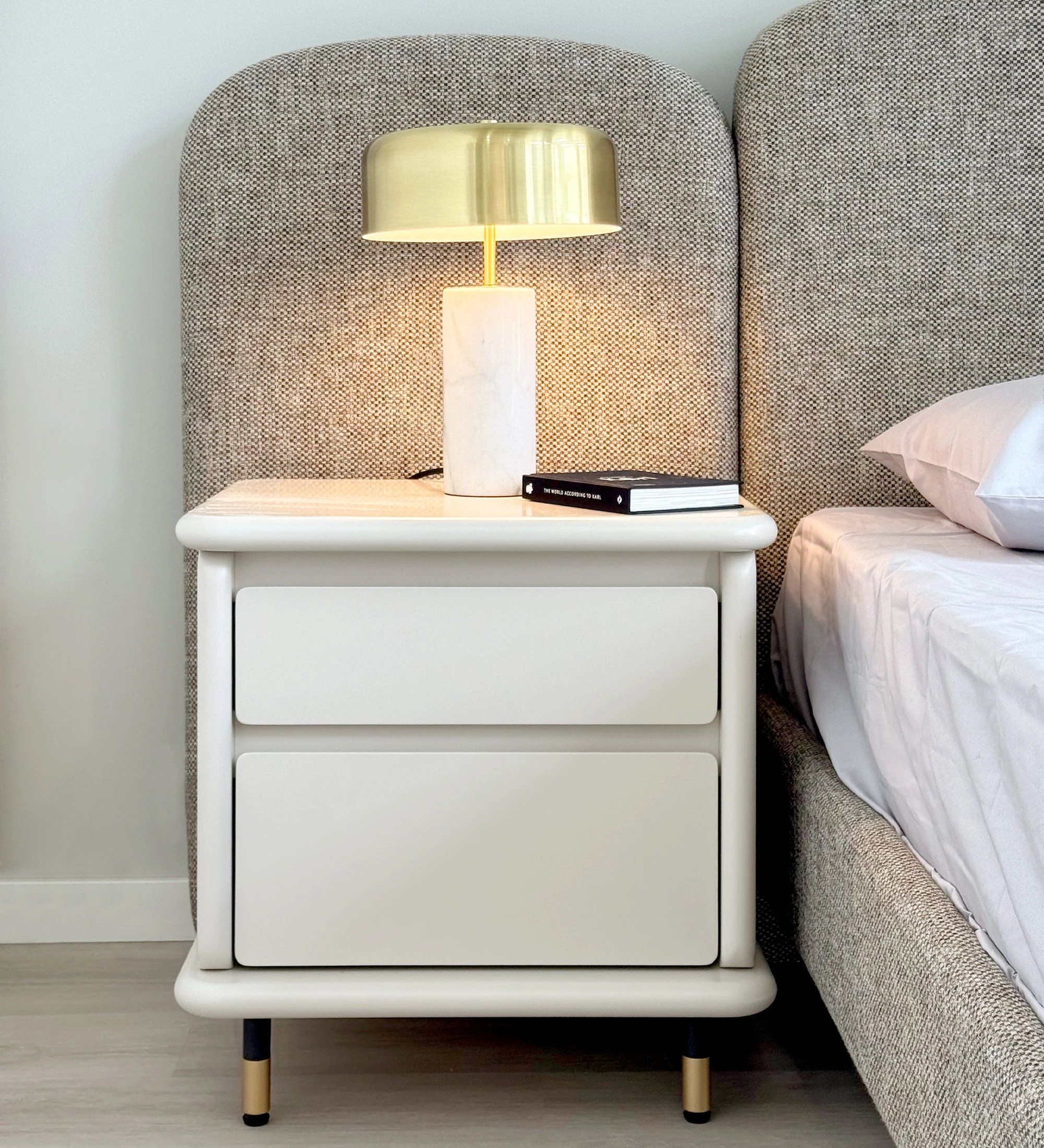 Bedside table with 2 drawers and structure in pearl lacquered, black lacquered feet with golden detail.