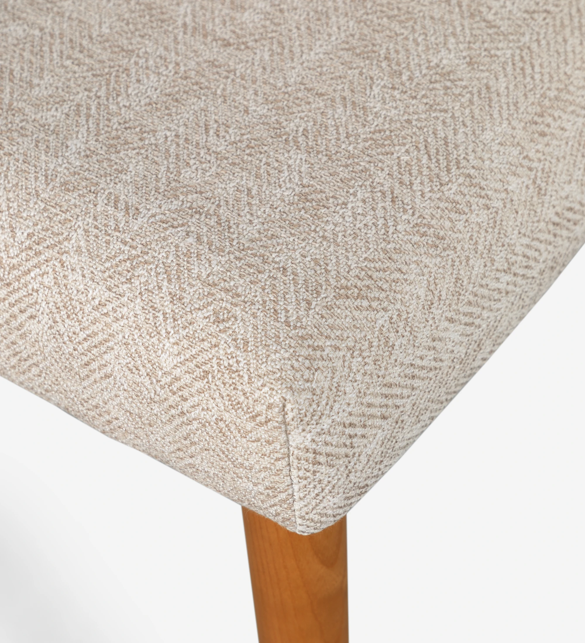 Chaise Oslo rembourré en tissu beige et pieds en bois couleur miel.