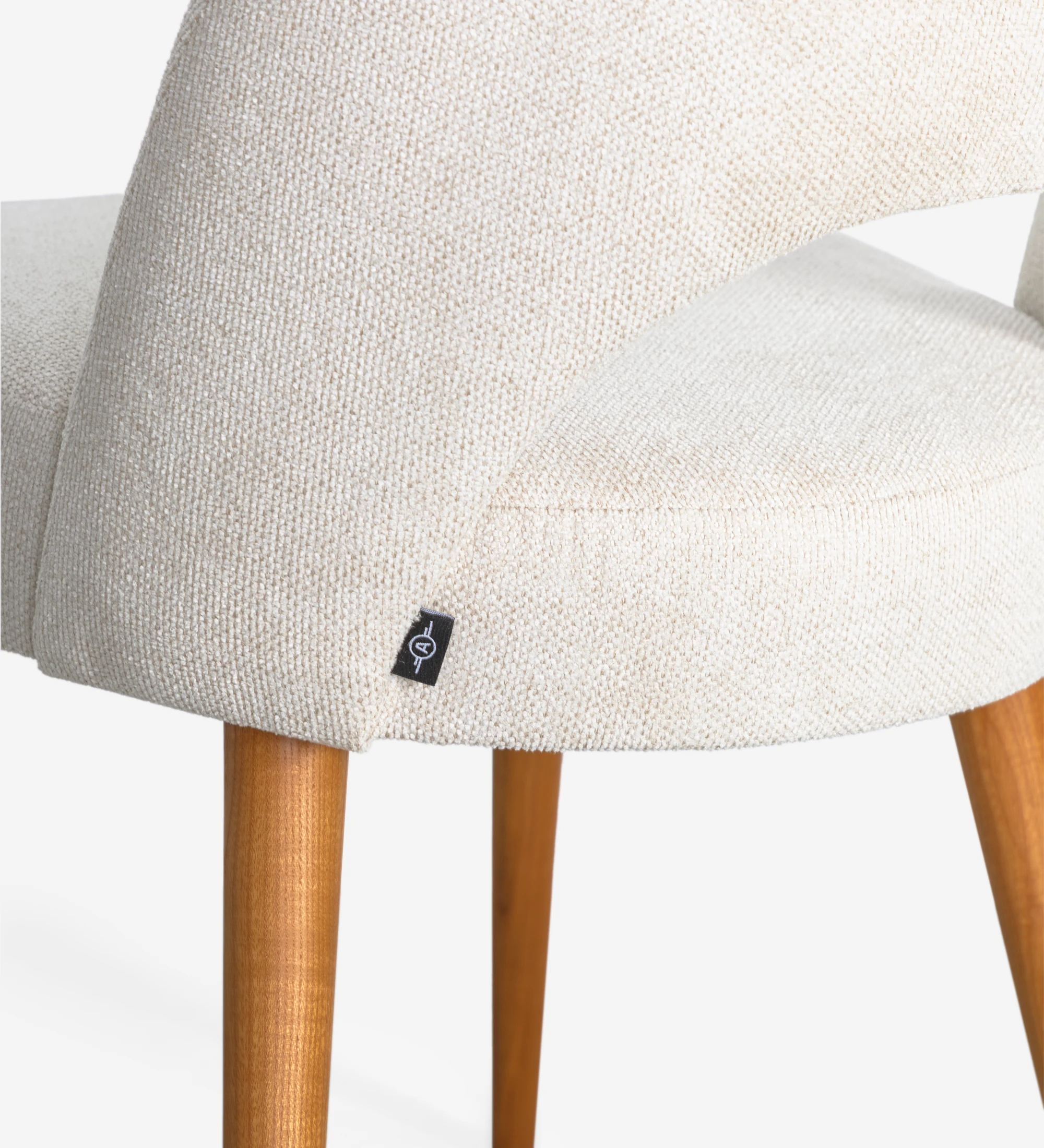 Silla tapizada en tejido, con pies de madera color miel.