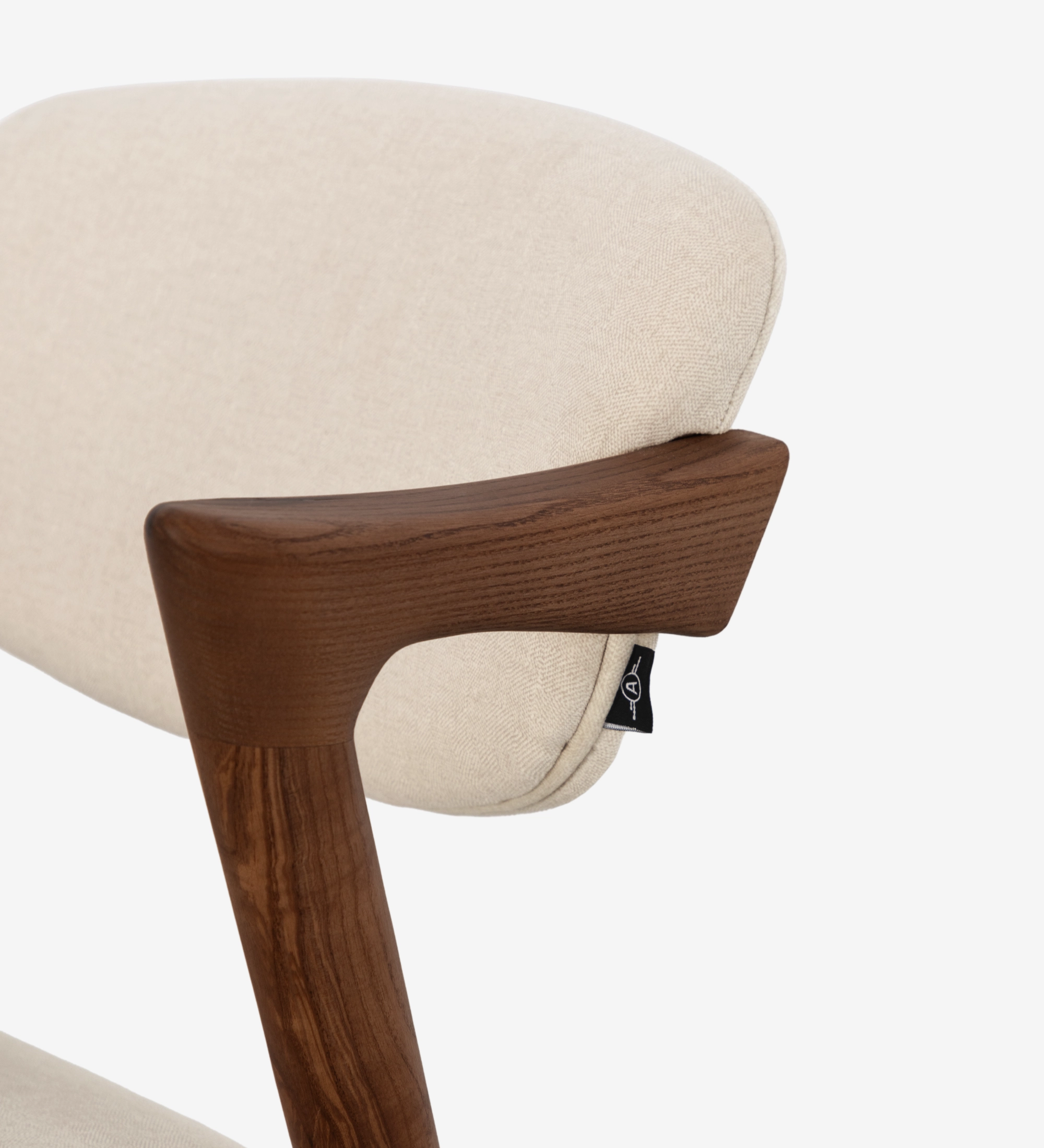 Silla en madera de fresno color nogal, con asiento y respaldo tapizado en tejido.