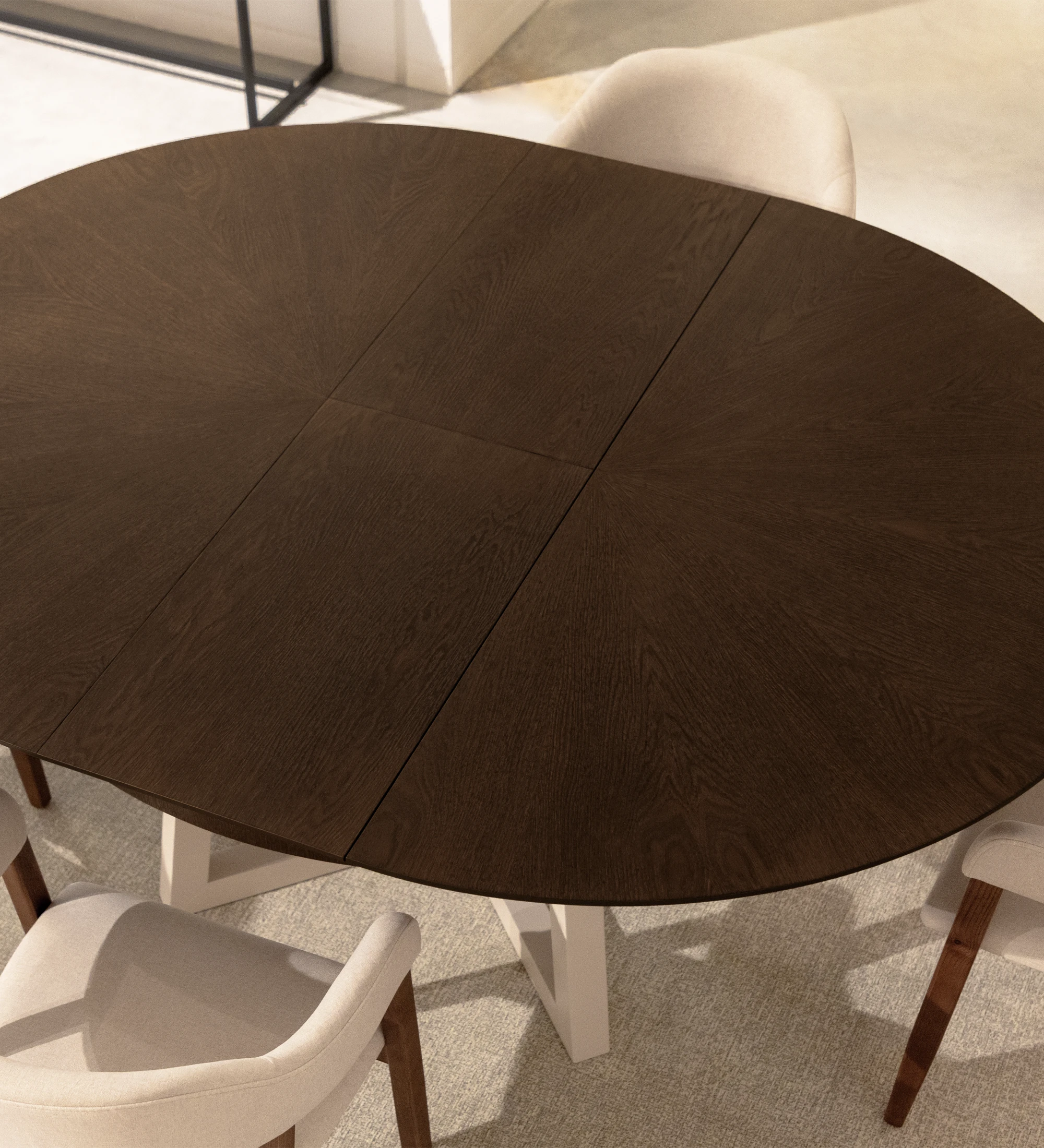 Mesa de comedor redonda extensible con tablero en roble nogal y pies lacados perla.