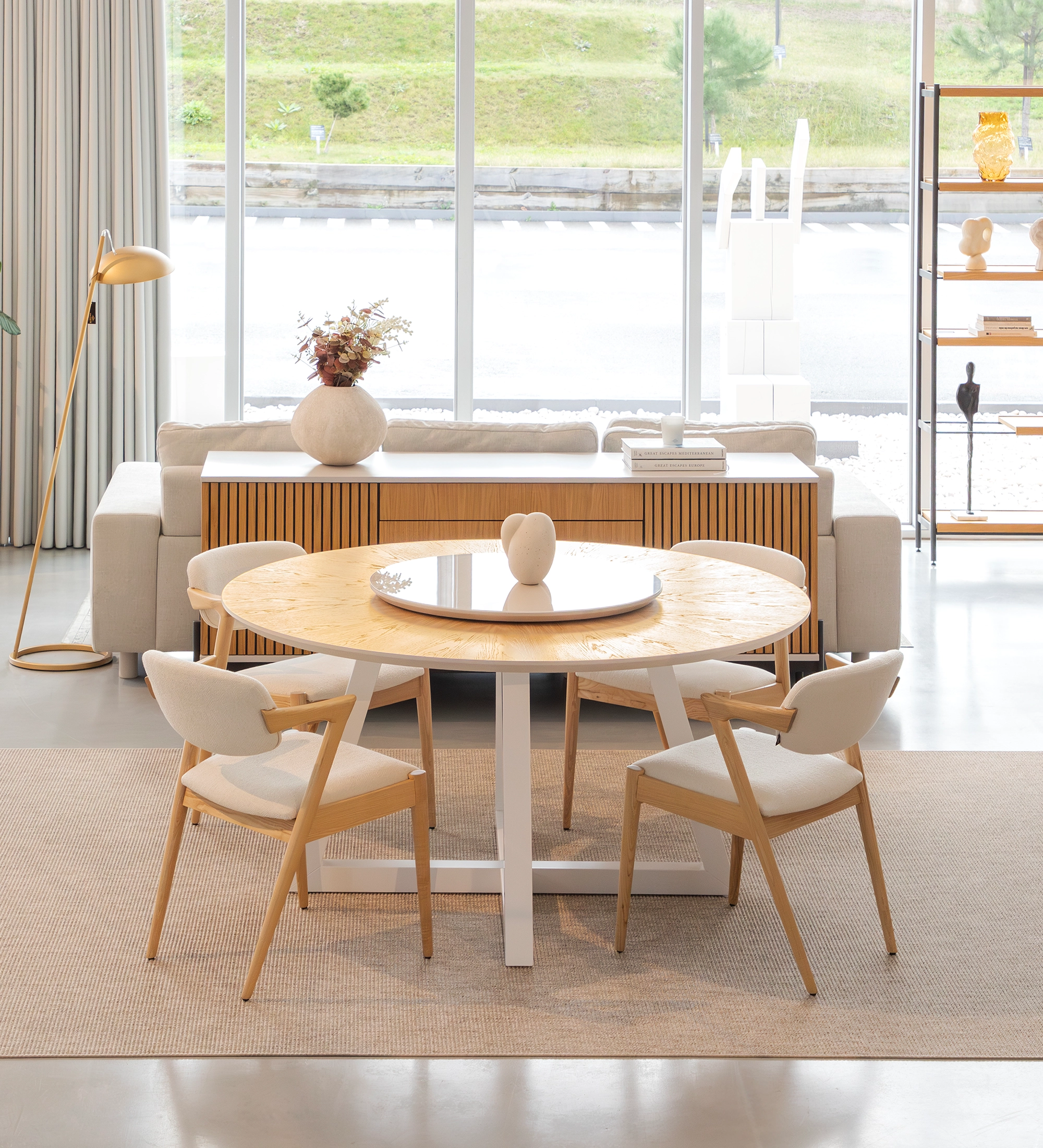 Table de repas ronde Nice Ø 150 cm, plateau bas en chêne naturel, plateau tournant en verre et pieds laqués nacrés.