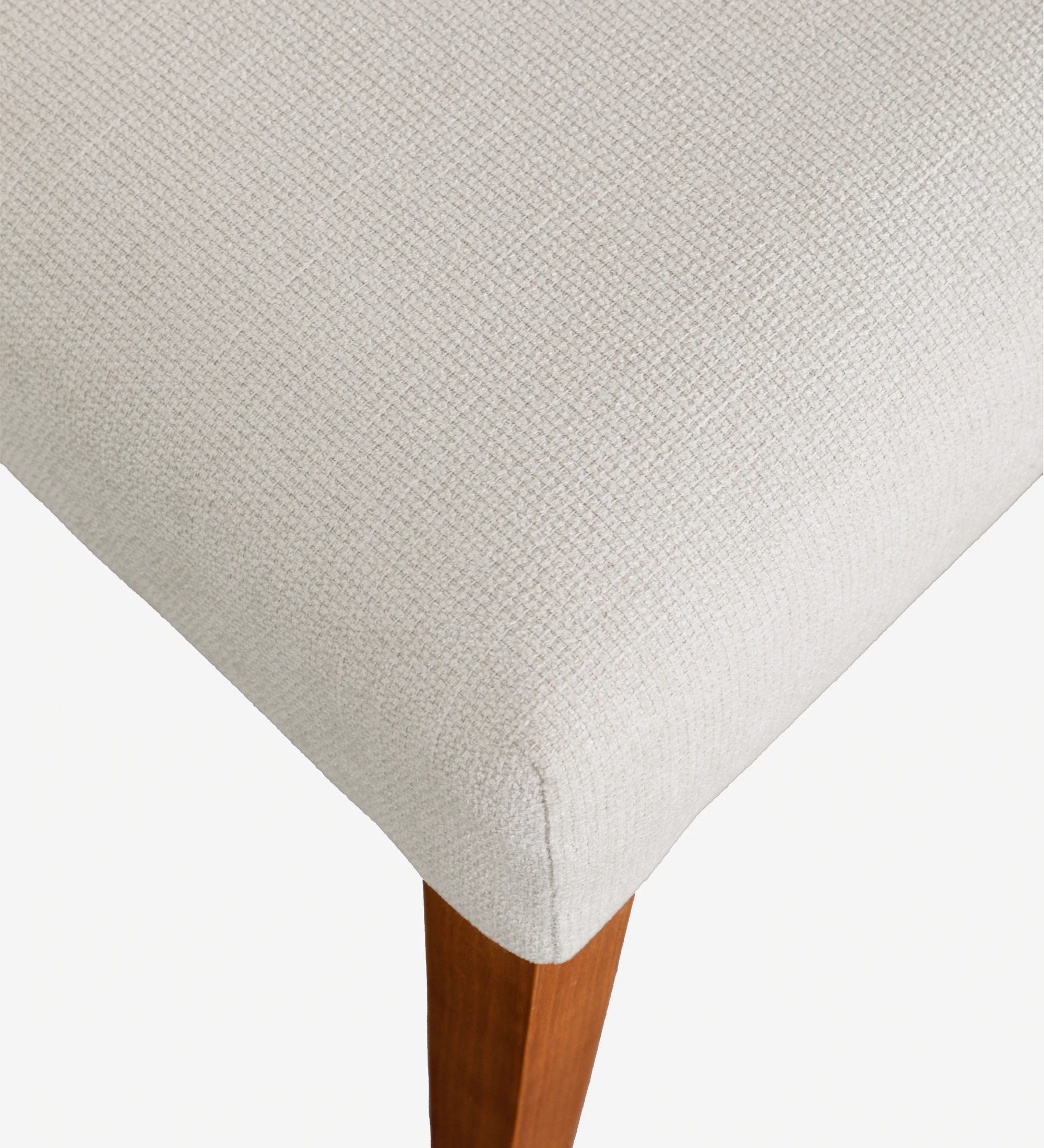 Silla tapizada en tela beige, con patas de madera color miel.