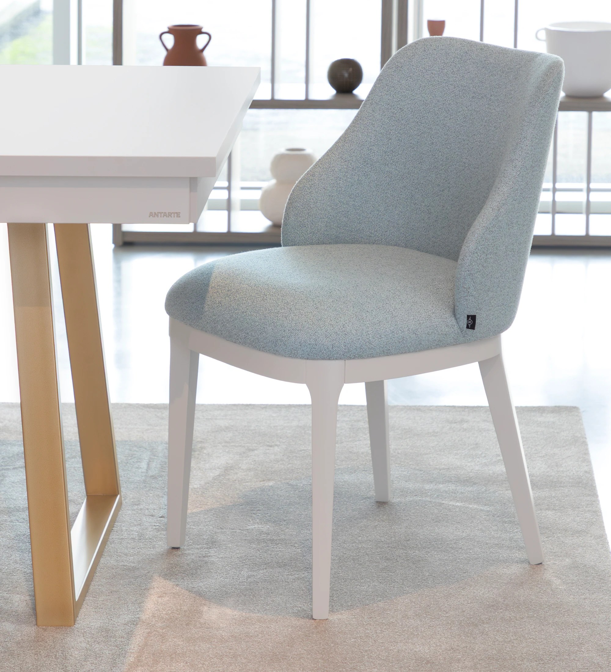 Chair upholstered in blue fabric, with pearl lacquered feet.