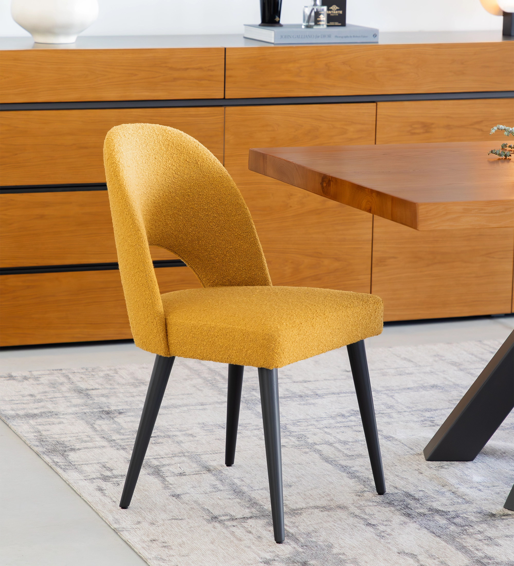 Silla tapizada en tejido amarillo, pies lacados en negro.