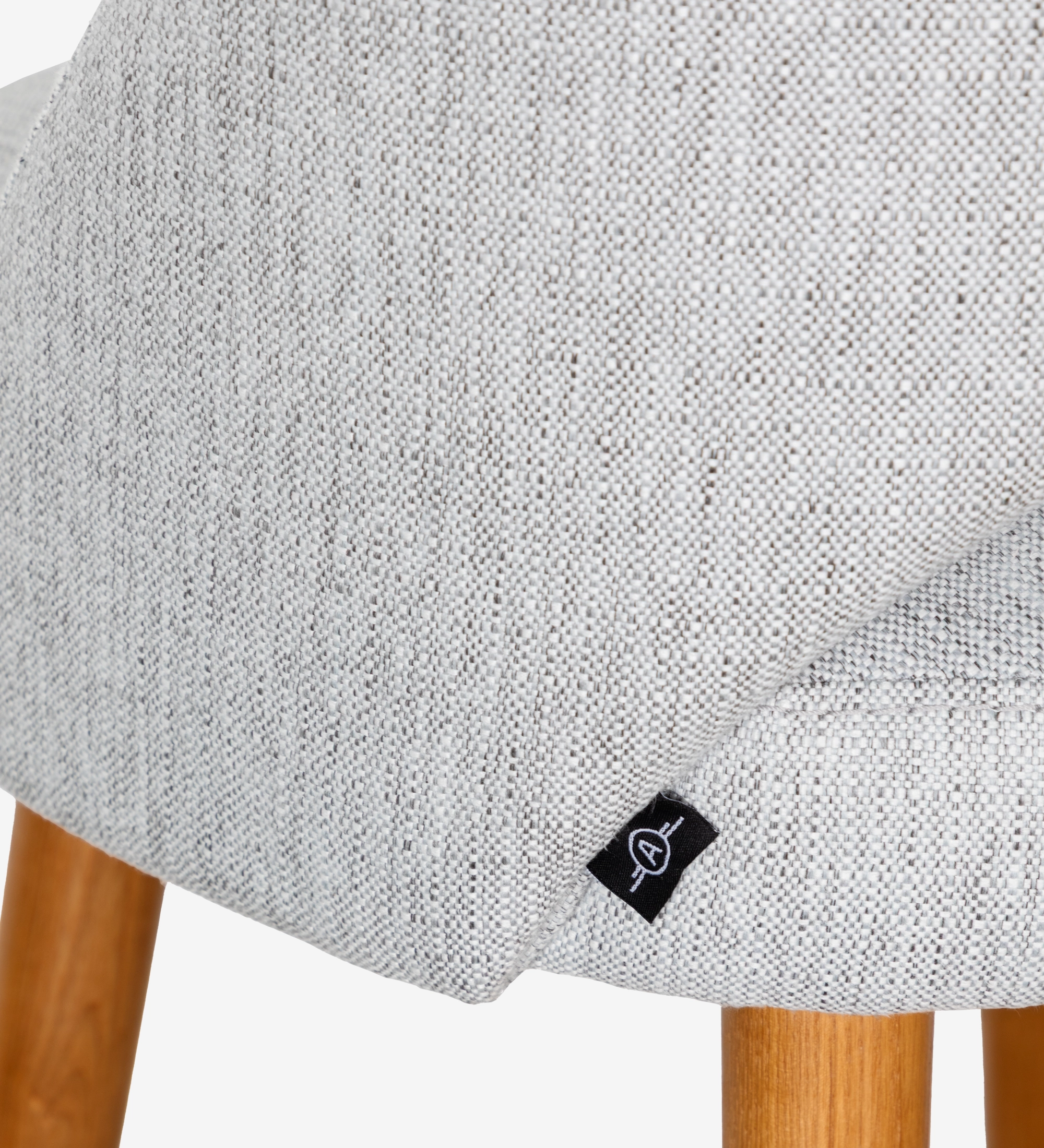 Taburete tapizados en tejido gris claro, con patas de madera color miel.