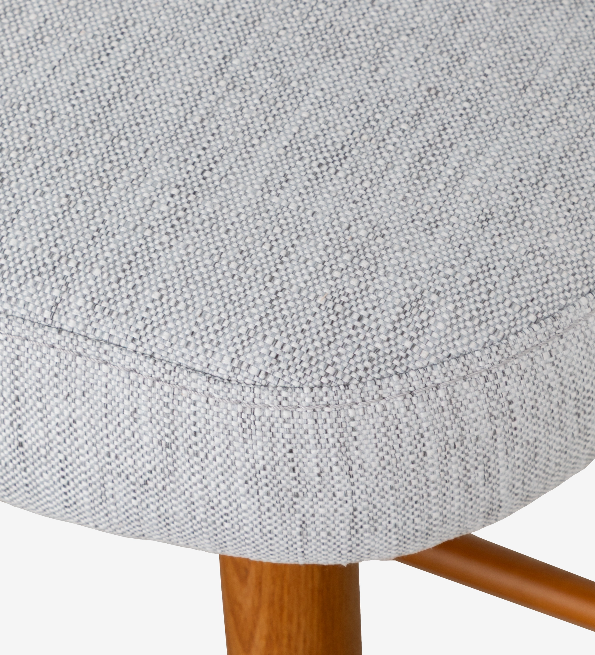 Taburete tapizados en tejido gris claro, con patas de madera color miel.