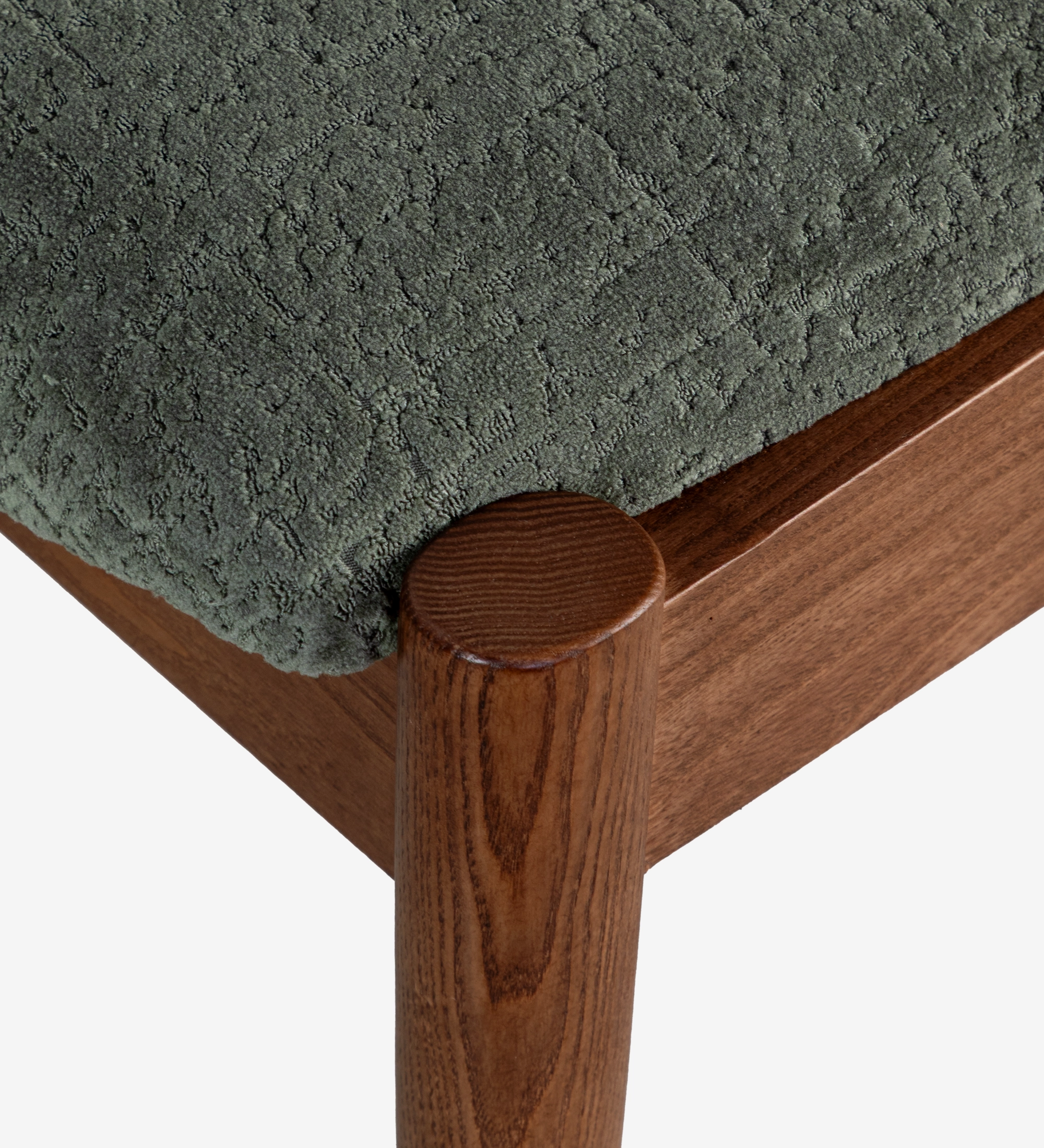 Chaise en bois de frêne couleur noyer, avec assise et dossier rembourrés en tissu vert.