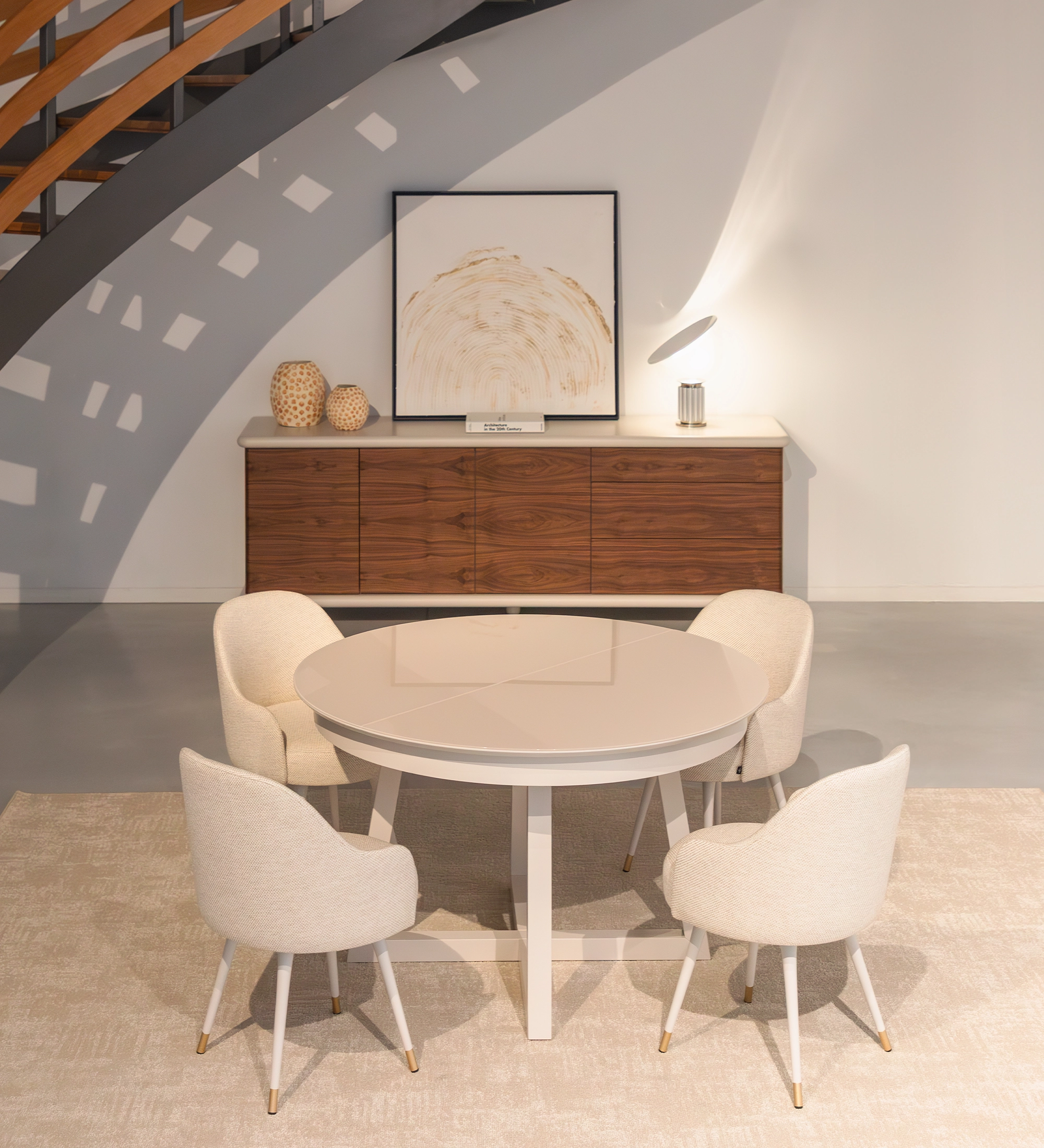 Mesa de comedor redonda extensible en lacado perla con tapa de cristal y extensión en lacado perla.