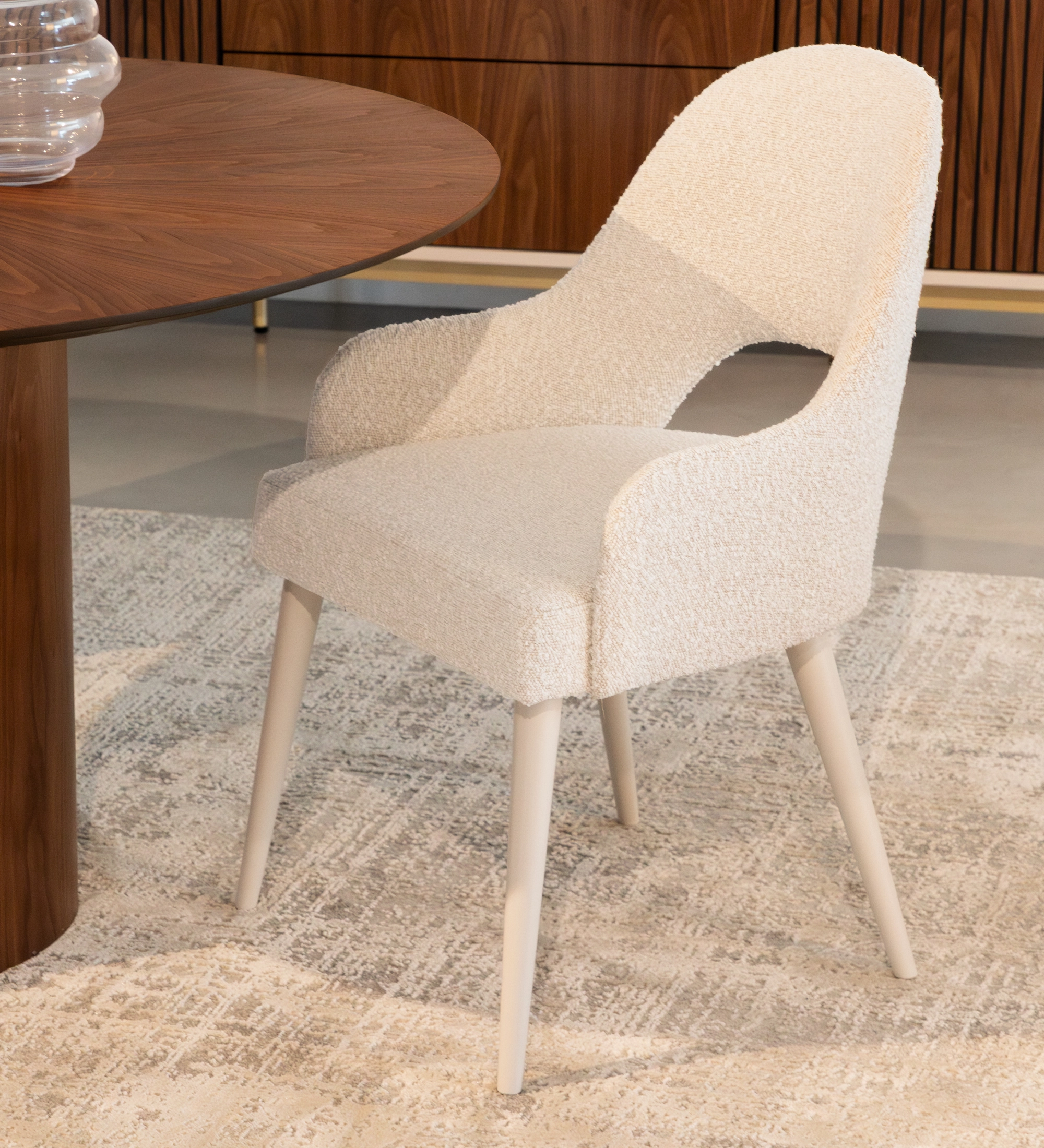 Silla con reposabrazos tapizado en tela perla, con patas lacadas en perla.