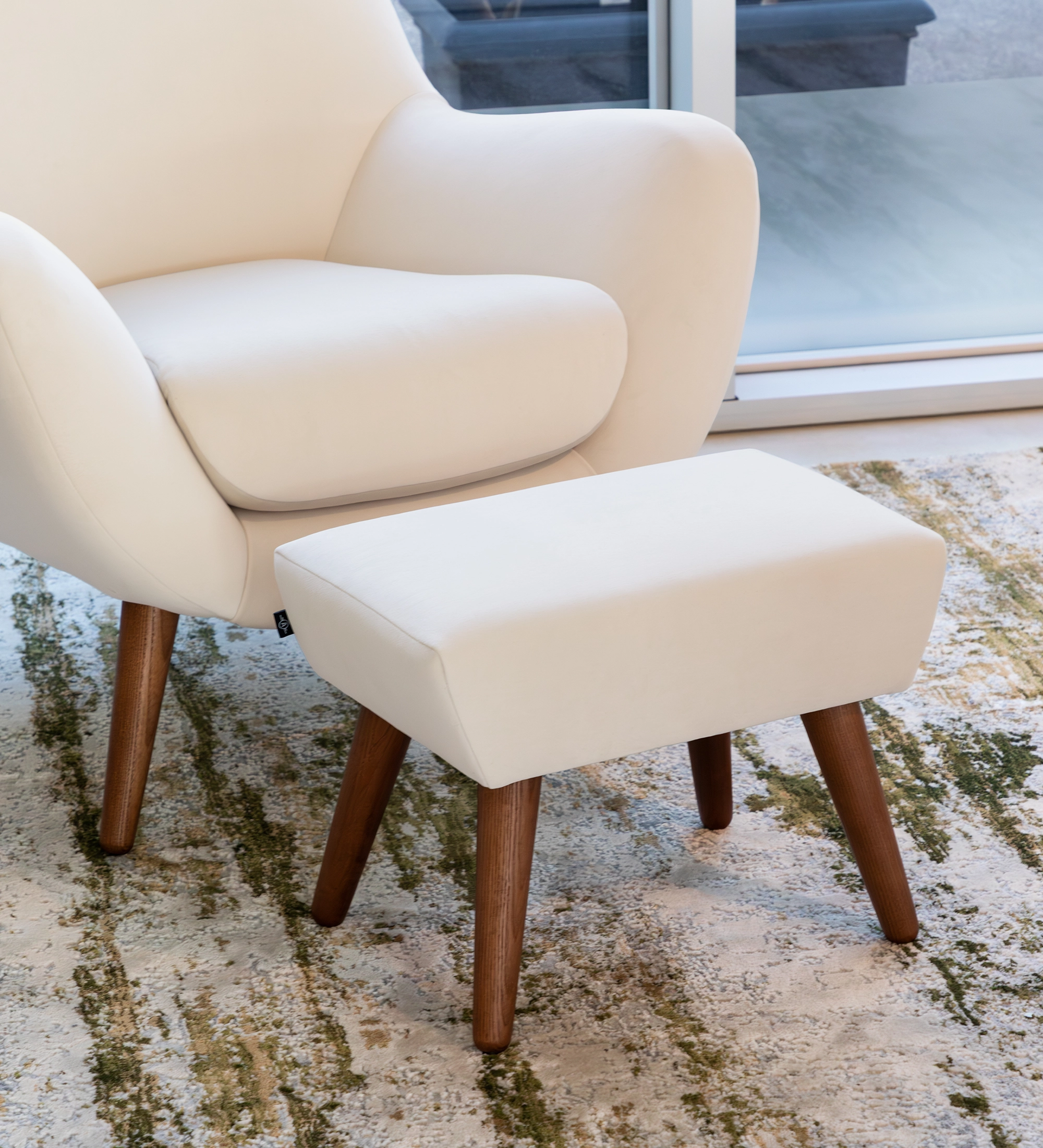 Upholstered in pearl fabric with walnut-colored ash wood legs.