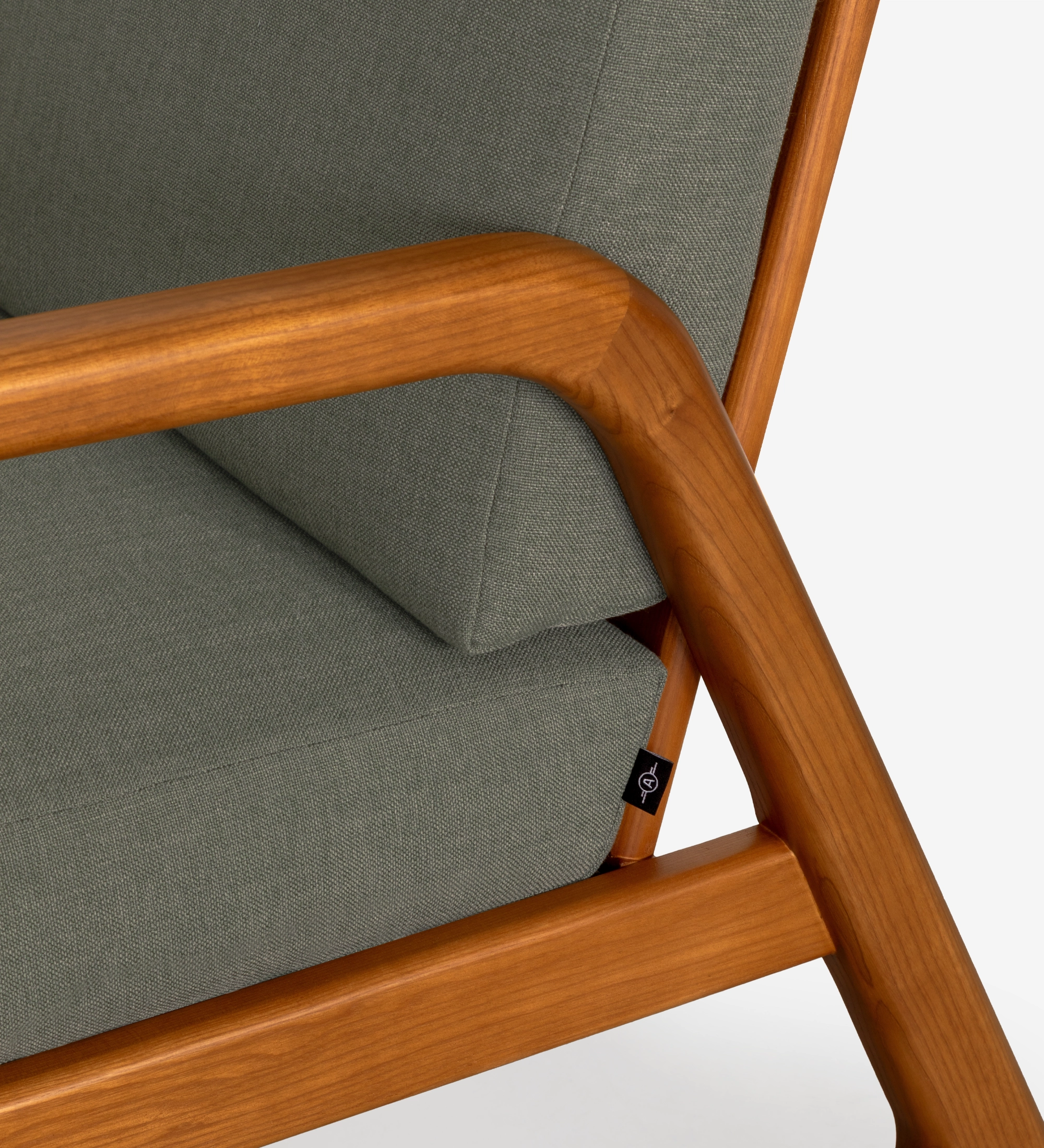 Sillón Antarte by IA tapizado en tela verde, estructura en madera color miel.