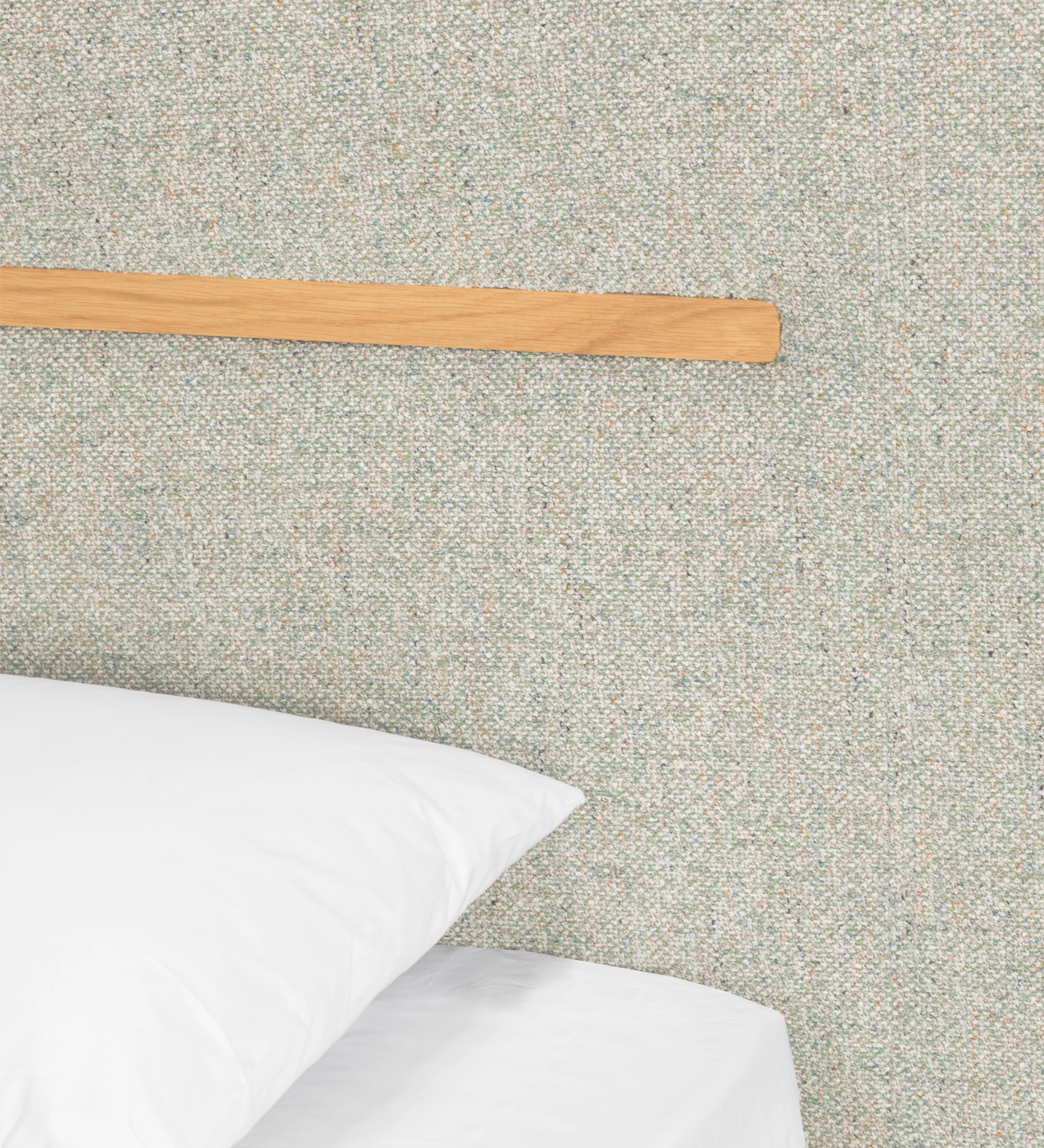 Cama de casal com cabeceira e base suspensa estofada em tecido verde, pormenor em carvalho natural.