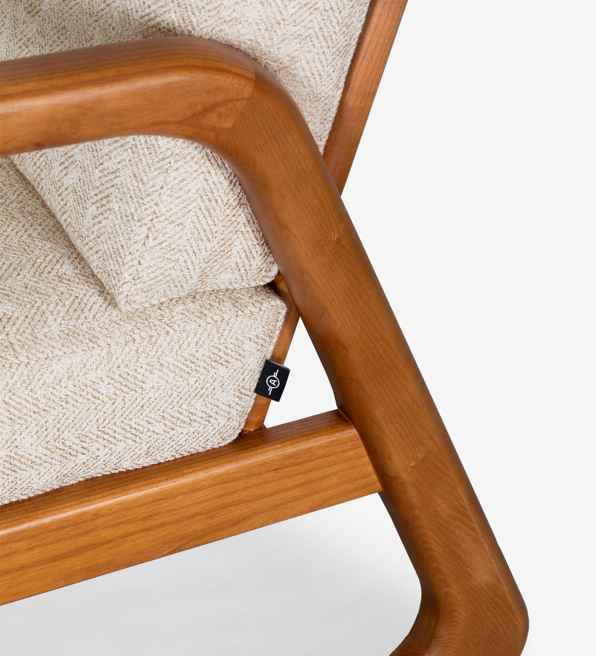 Fauteuil Antarte by IA recouvert en tissu beige, structure en bois couleur miel.