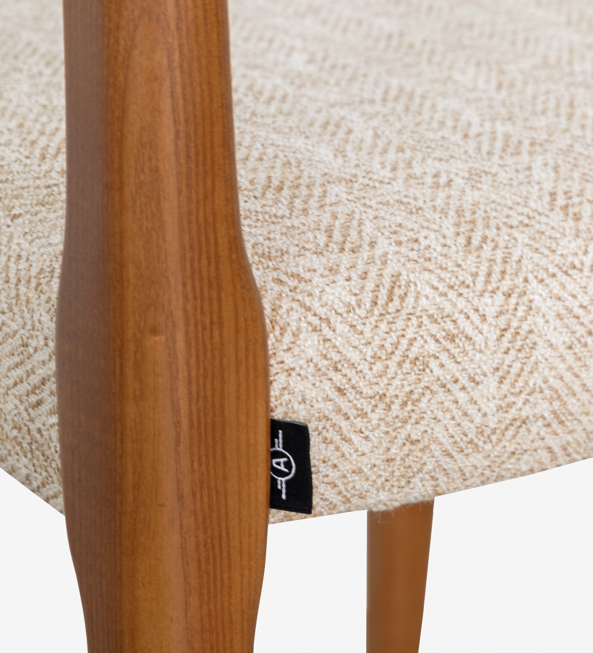 Chair in honey colored ash wood with beige fabric upholstered seat.