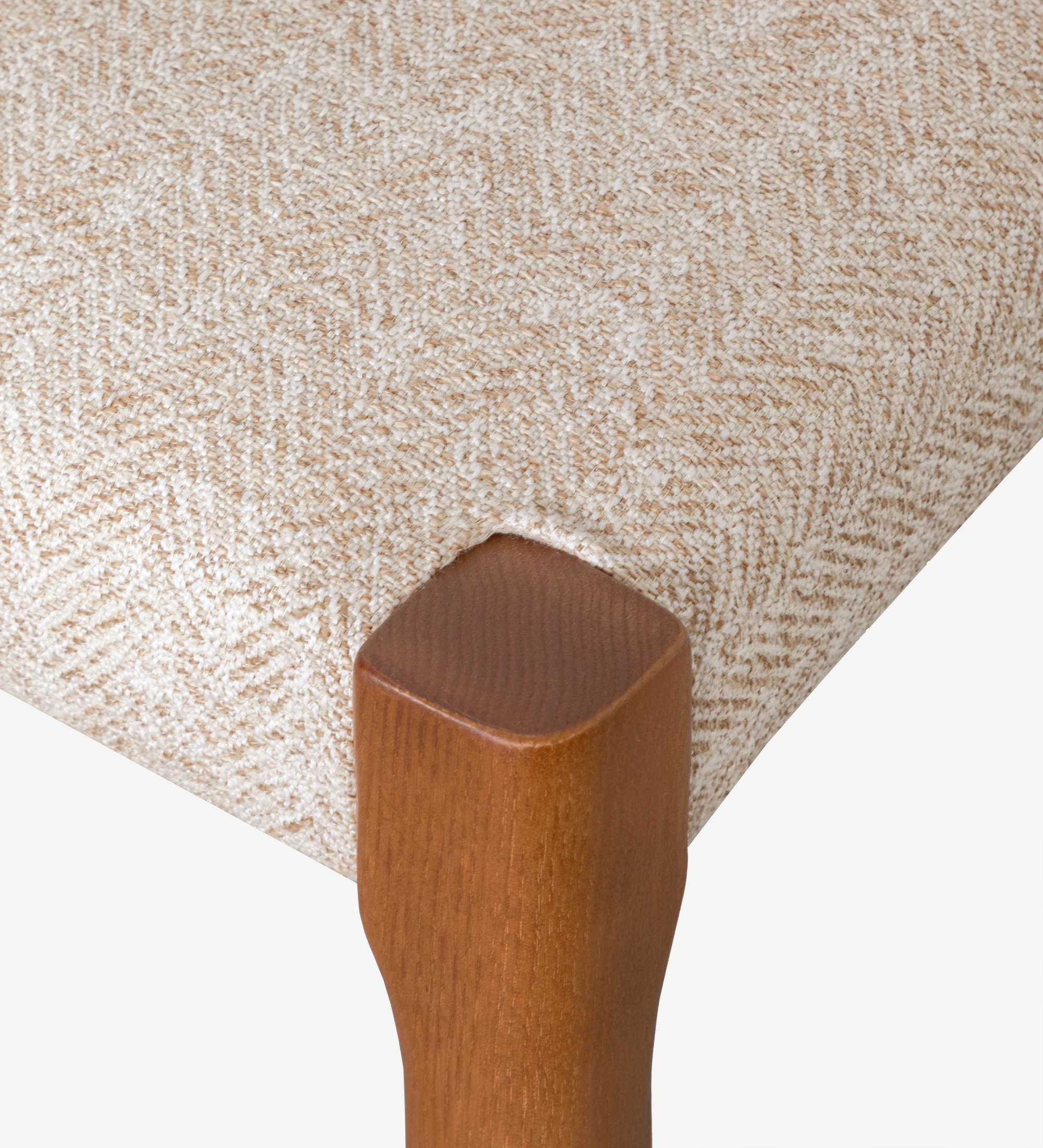 Chair in honey colored ash wood with beige fabric upholstered seat.