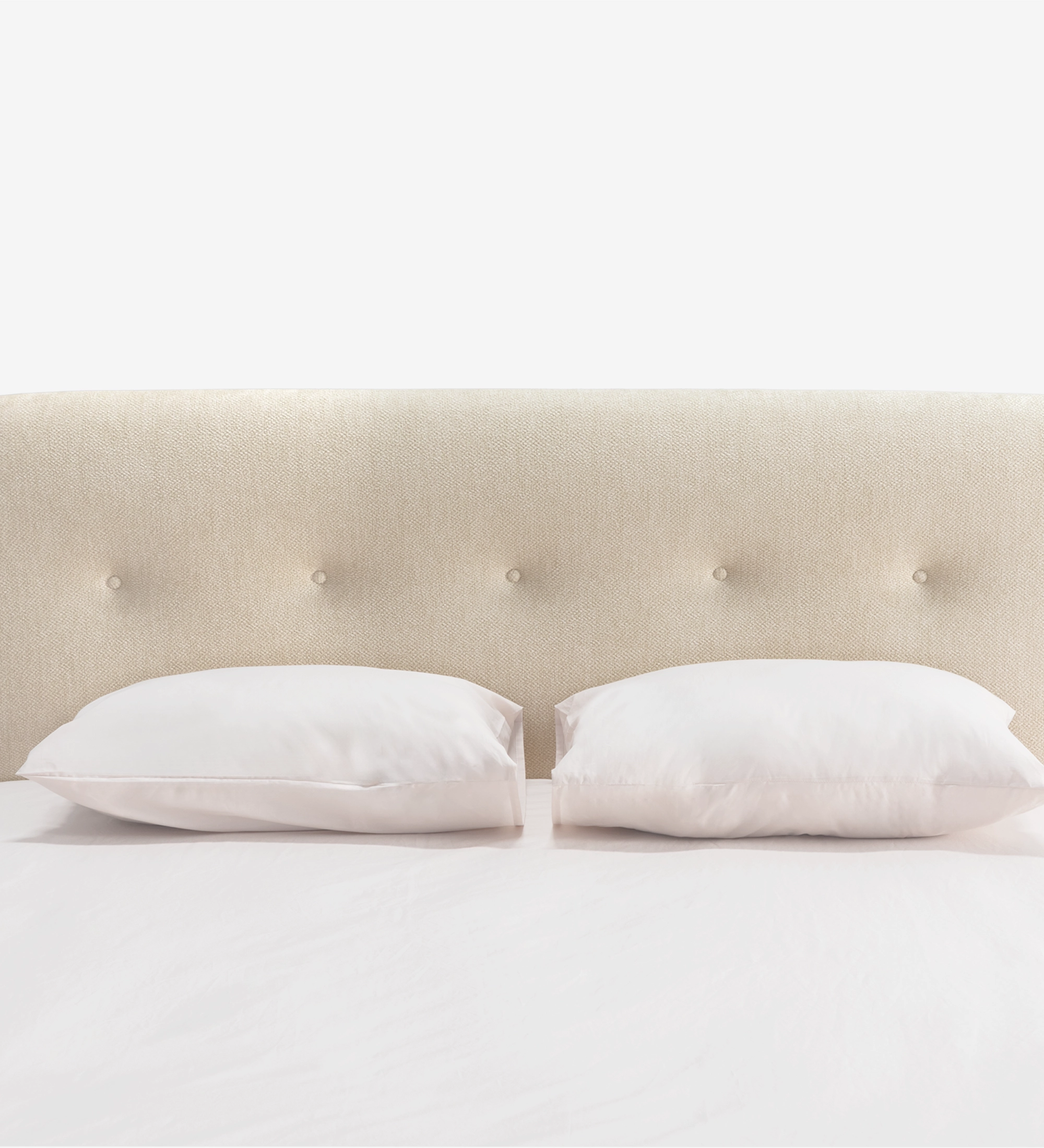 Cama de casal com cabeceira curta, estofada a tecido bege.
