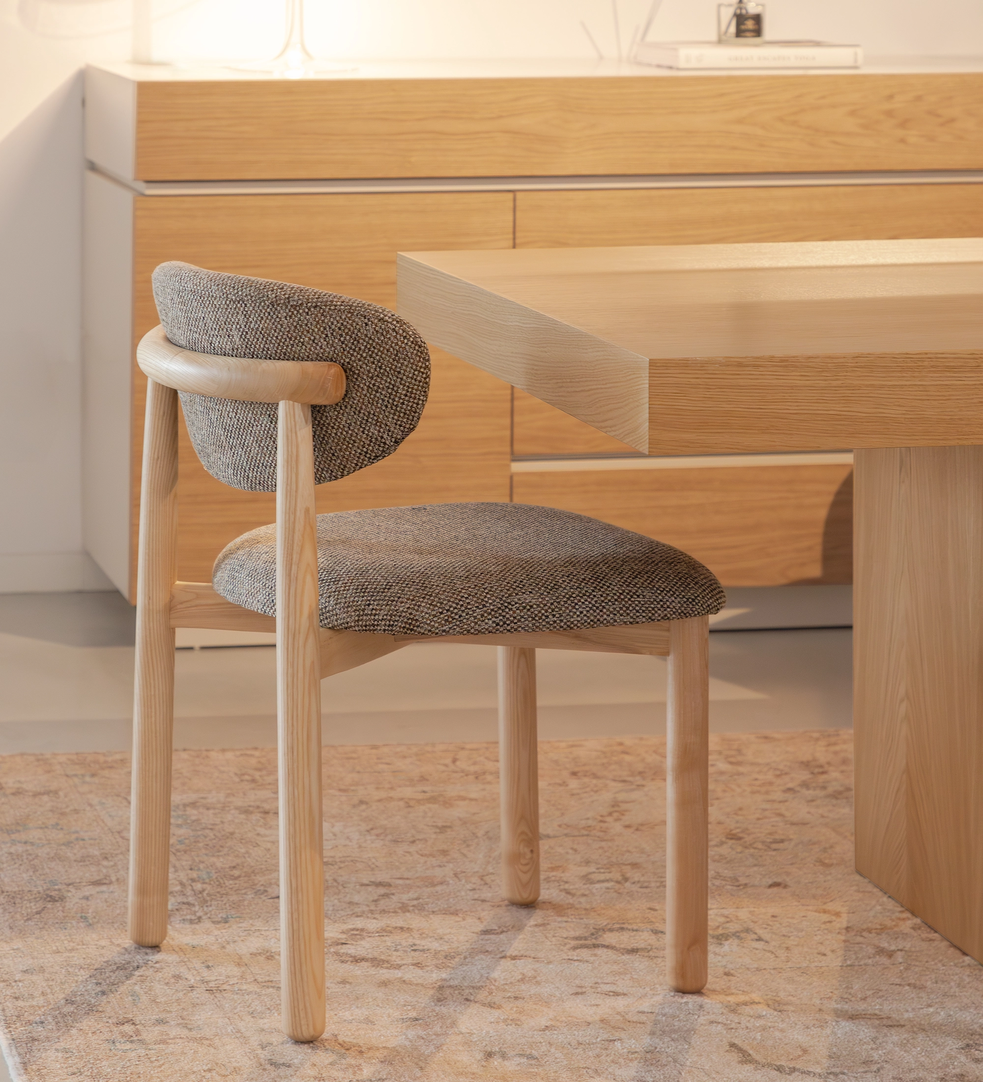 Chair in natural ash wood, with seat and backrest upholstered in multicolored fabric, primarily brown and pearl.