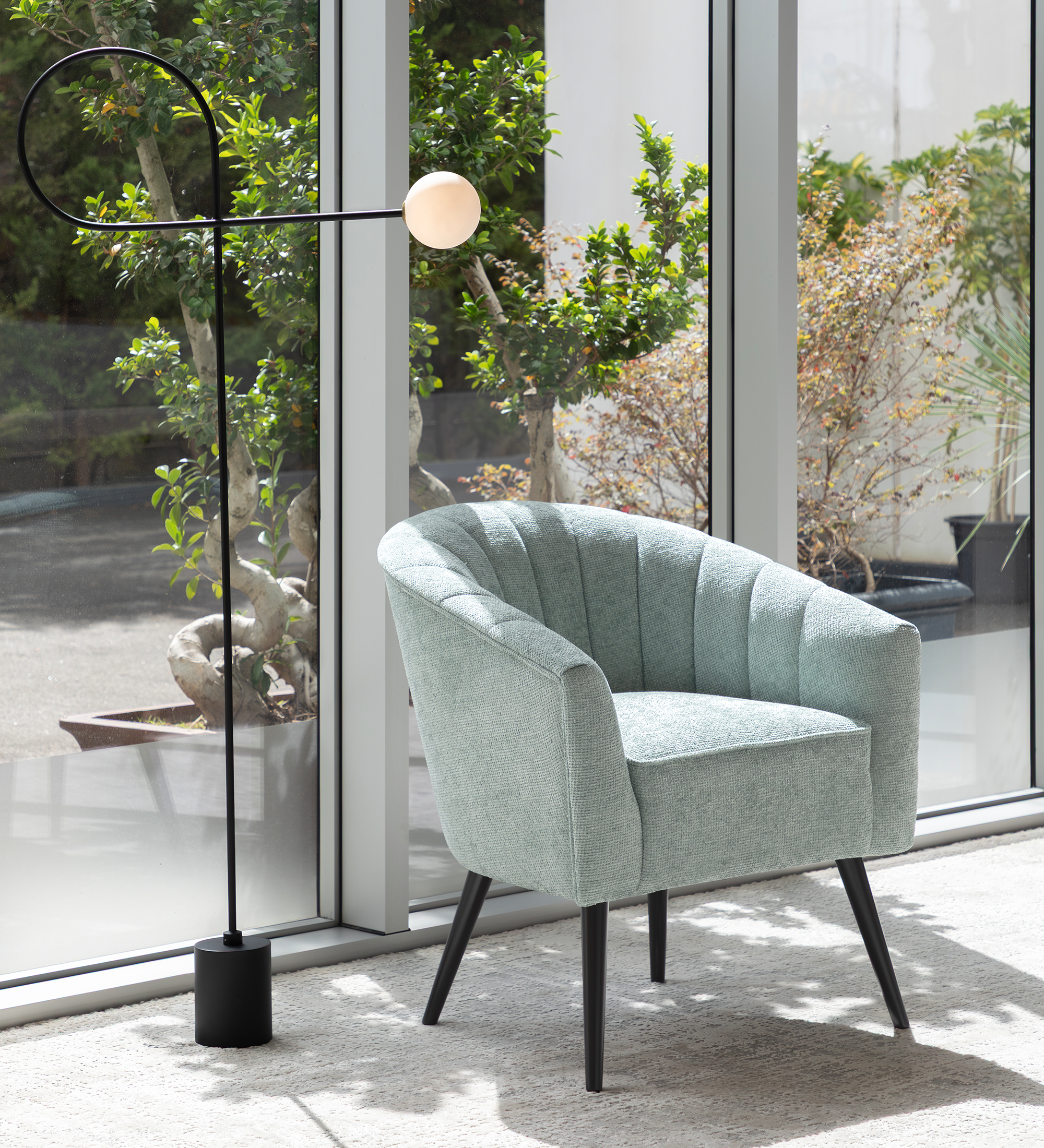 Tokyo armchair upholstered in aqua green fabric, black lacquered legs.