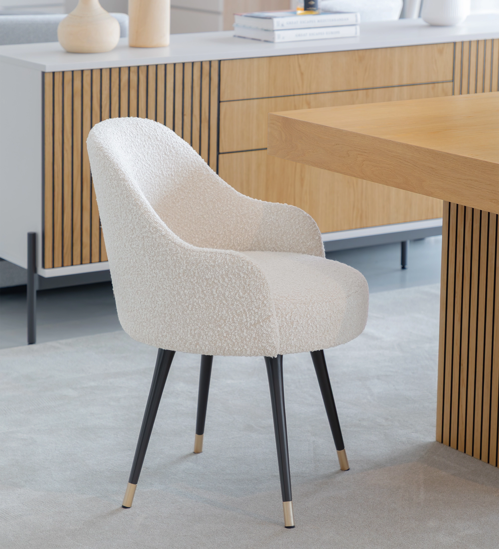 Pearl fabric upholstered swivel chair with black lacquered legs and gold detailing.