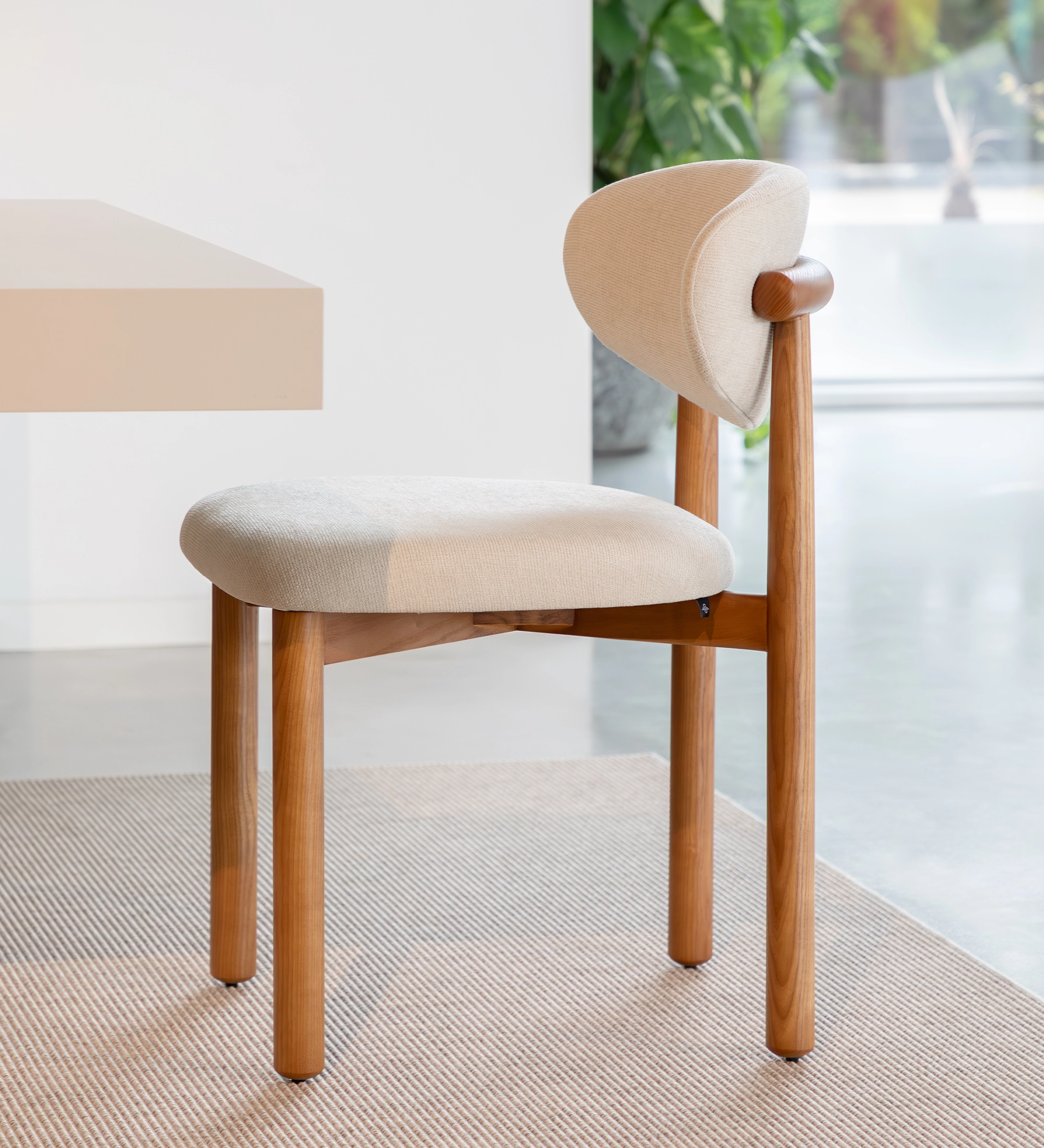 Chair in honey-colored ash wood, with seat and backrest upholstered in pearl fabric.