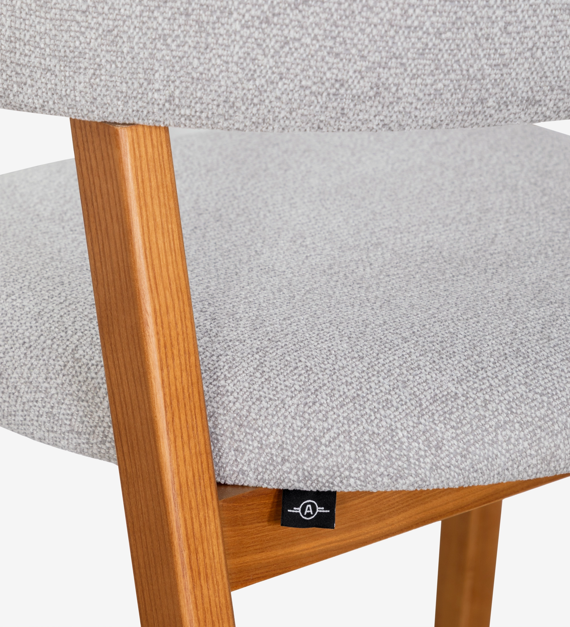 Silla con brazos, en madera de fresno color miel, con asiento y respaldo tapizados en tela gris claro