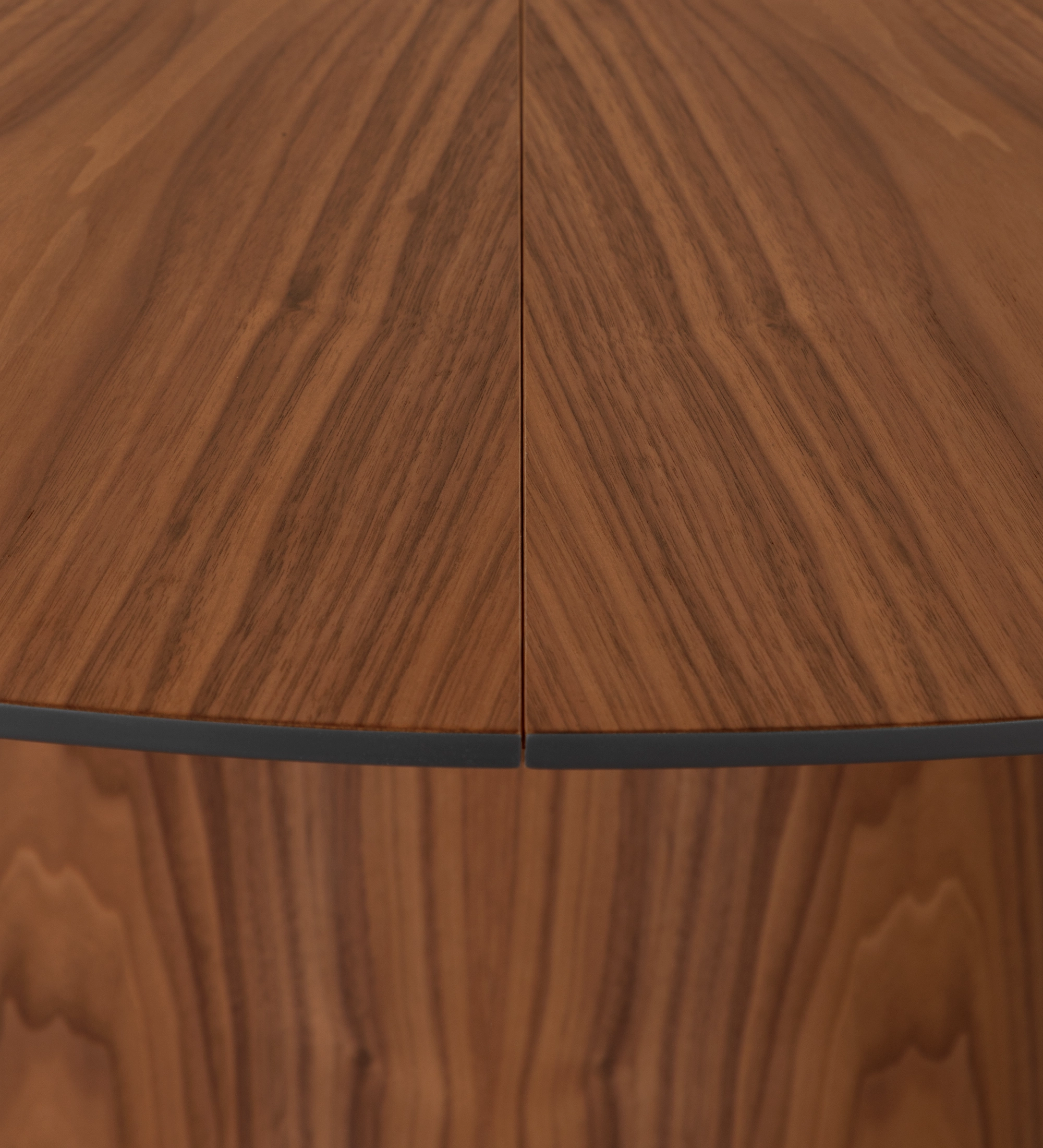 Table de repas ronde extensible Ø 130 cm, plateau en chevrons et pied en noyer naturel, détail du plateau laqué noir.