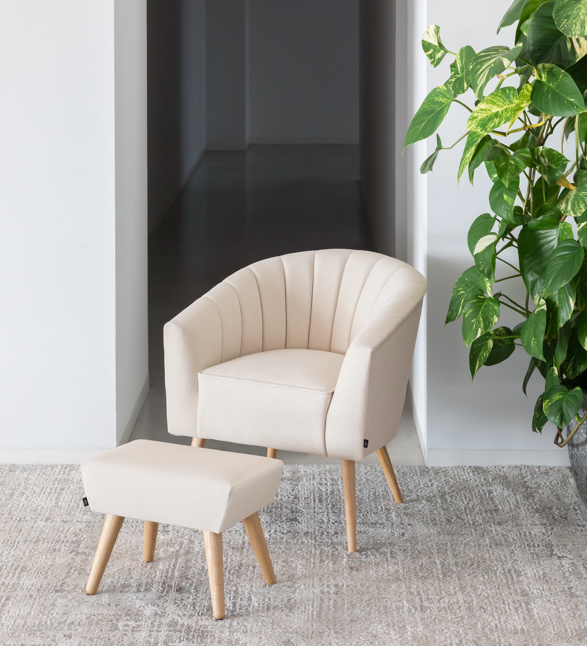 Fauteuil Tokyo recouvert en tissu beige, pieds laqués noir avec pieds en bois de couleur naturelle.