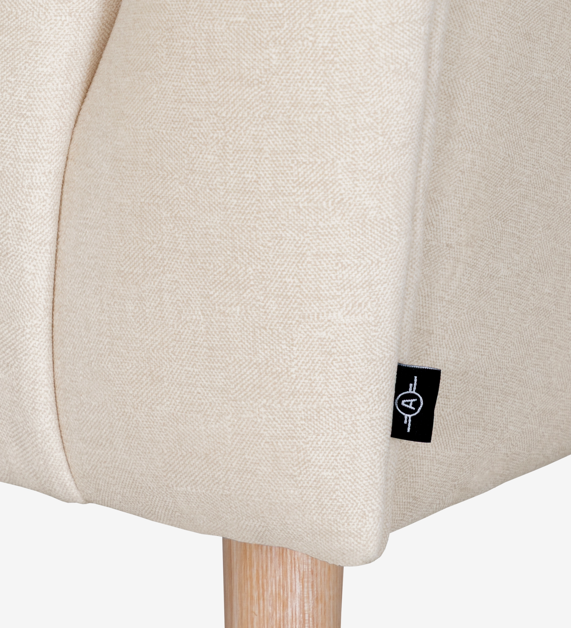 Fauteuil Tokyo recouvert en tissu beige, pieds laqués noir avec pieds en bois de couleur naturelle.