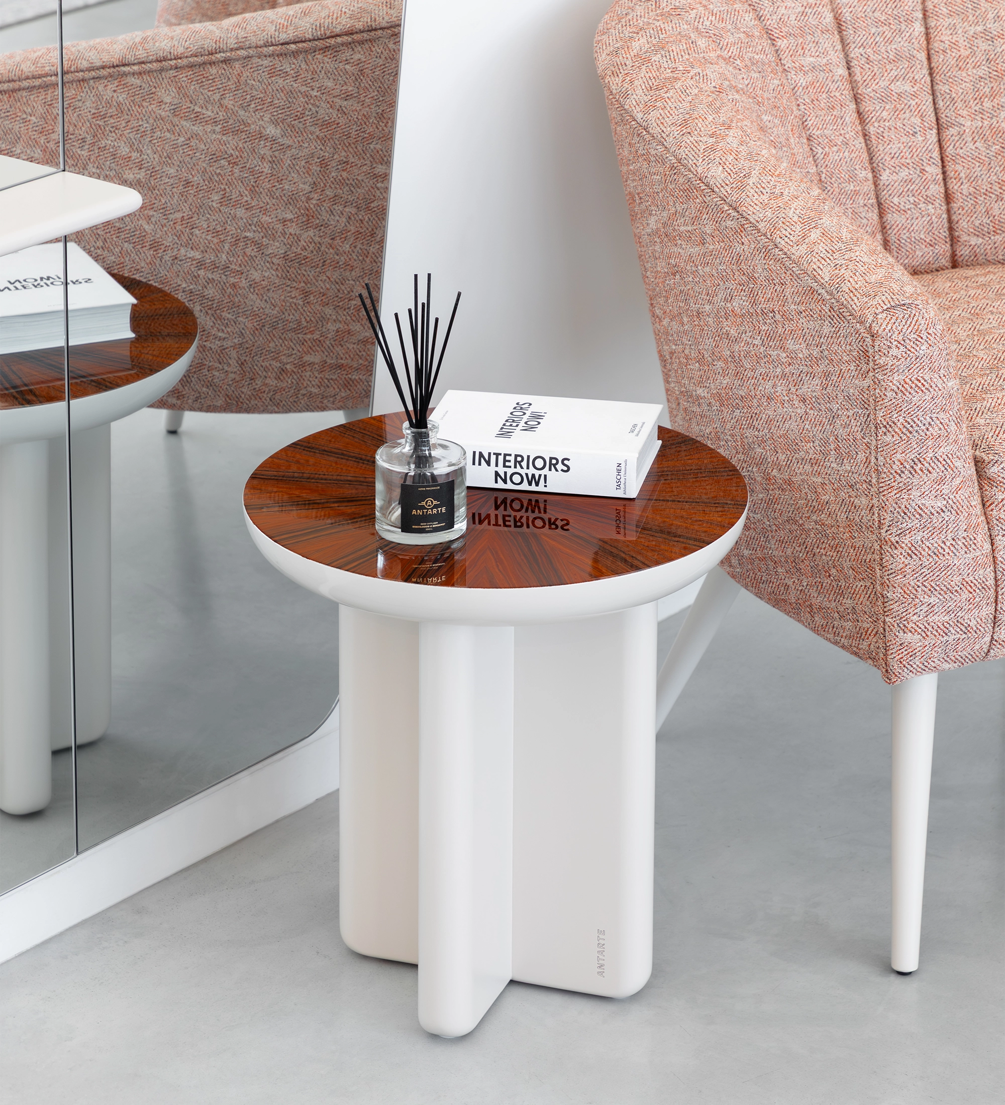 Mesa Auxiliar Mónaco blanca con tablero de madera y difusor, junto a butaca rosa