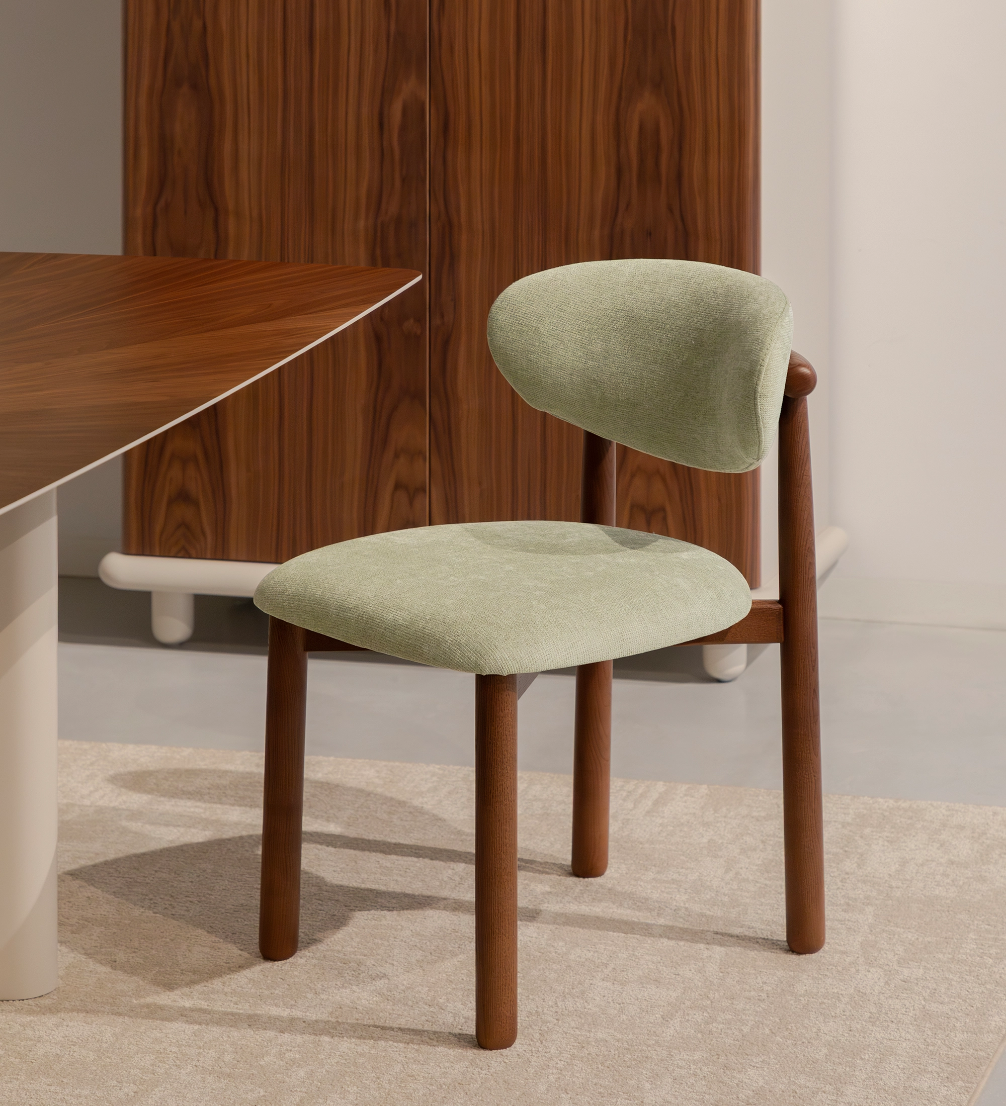 Chaise Nice en tissu vert clair avec pieds en bois foncé et dossier arrondi