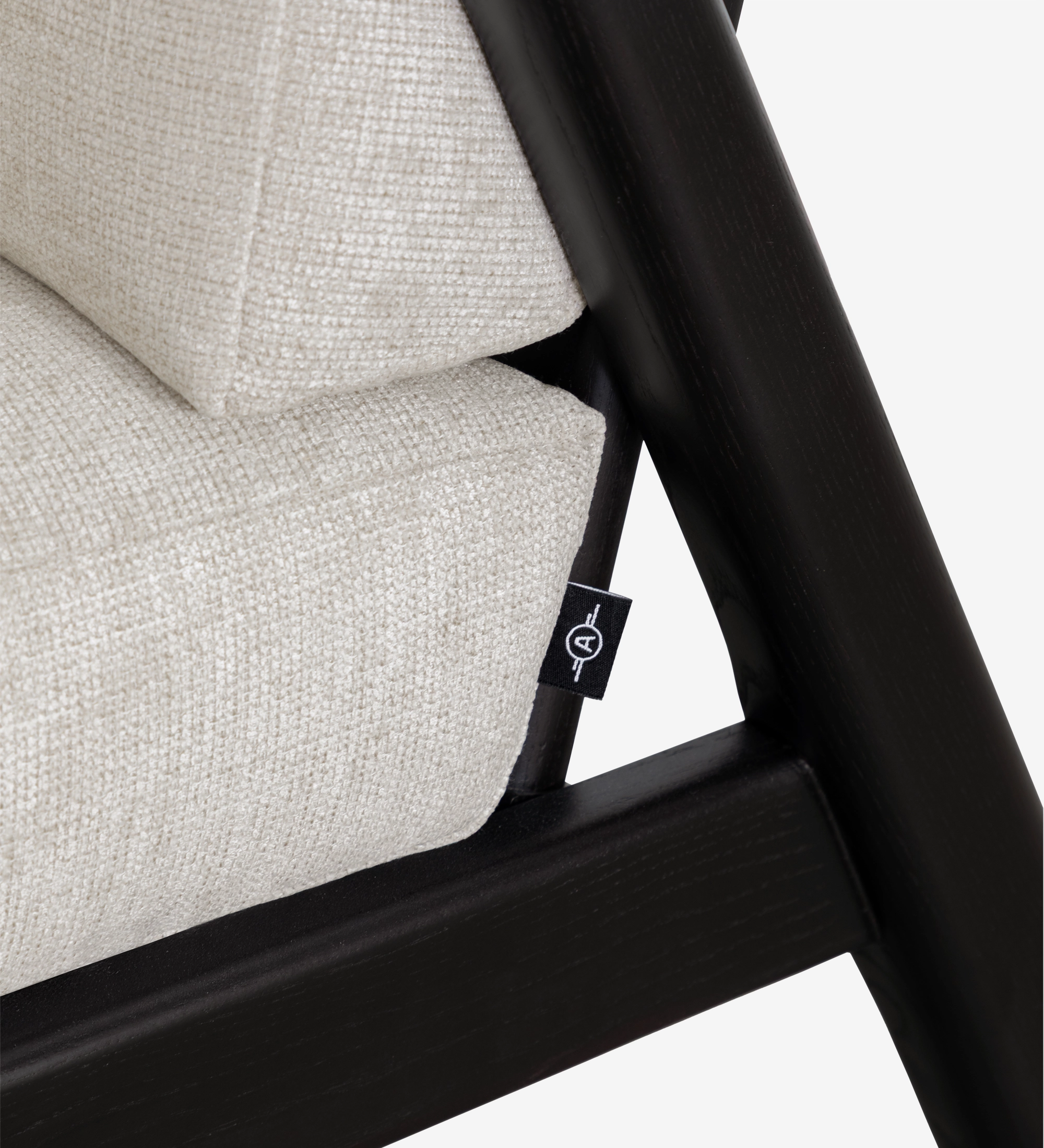 Fauteuil Antarte by IA gros plan coussin beige et cadre bois noir avec étiquette