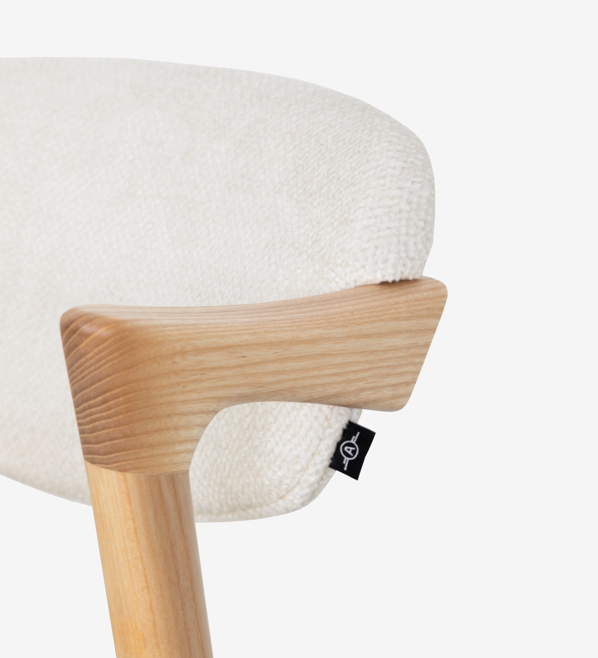 Elba Chair close-up of light wood armrest and cream textured fabric back