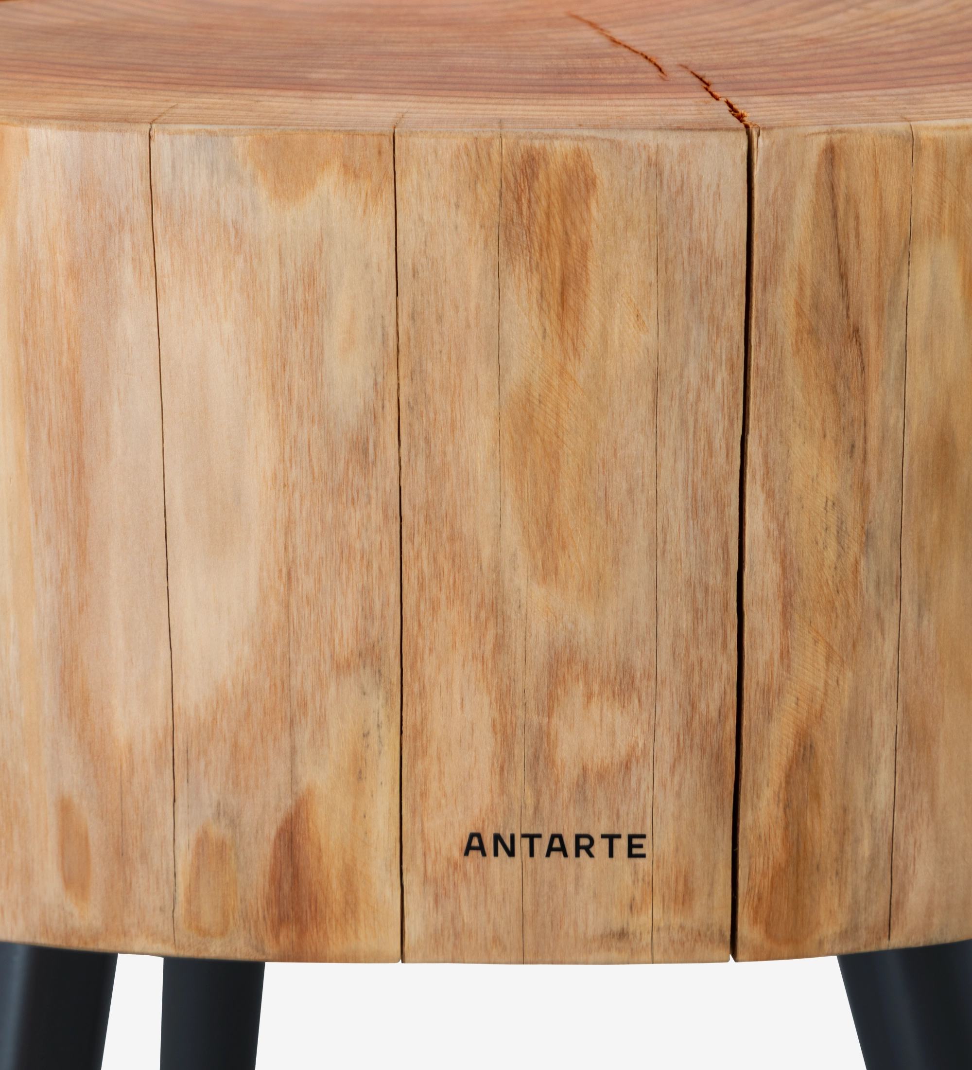 Mesa auxiliar tronco de madera clara con patas negras y logo Antarte