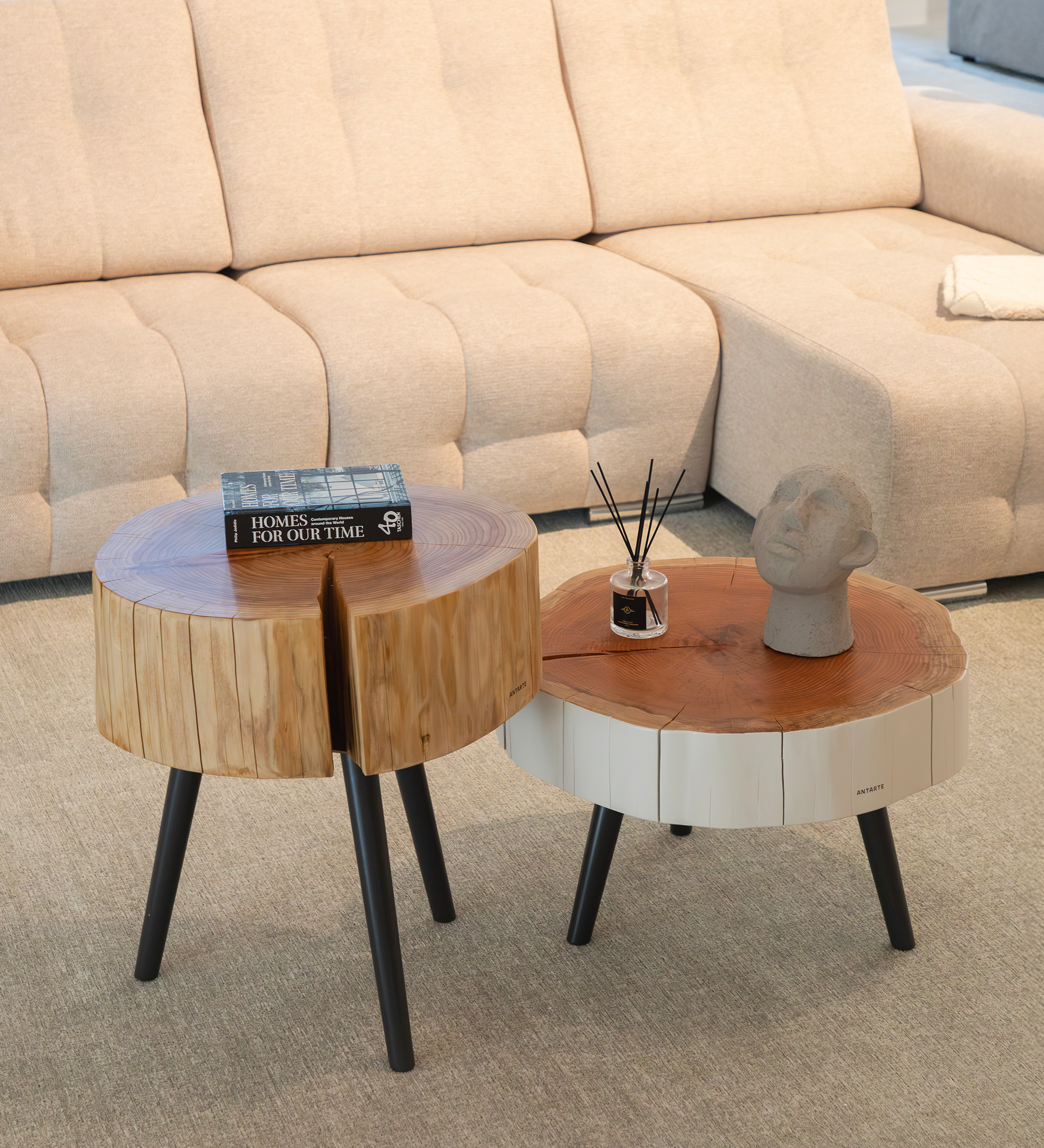 Trunk Center Table pair of round wooden stump tables with black legs, book and vase