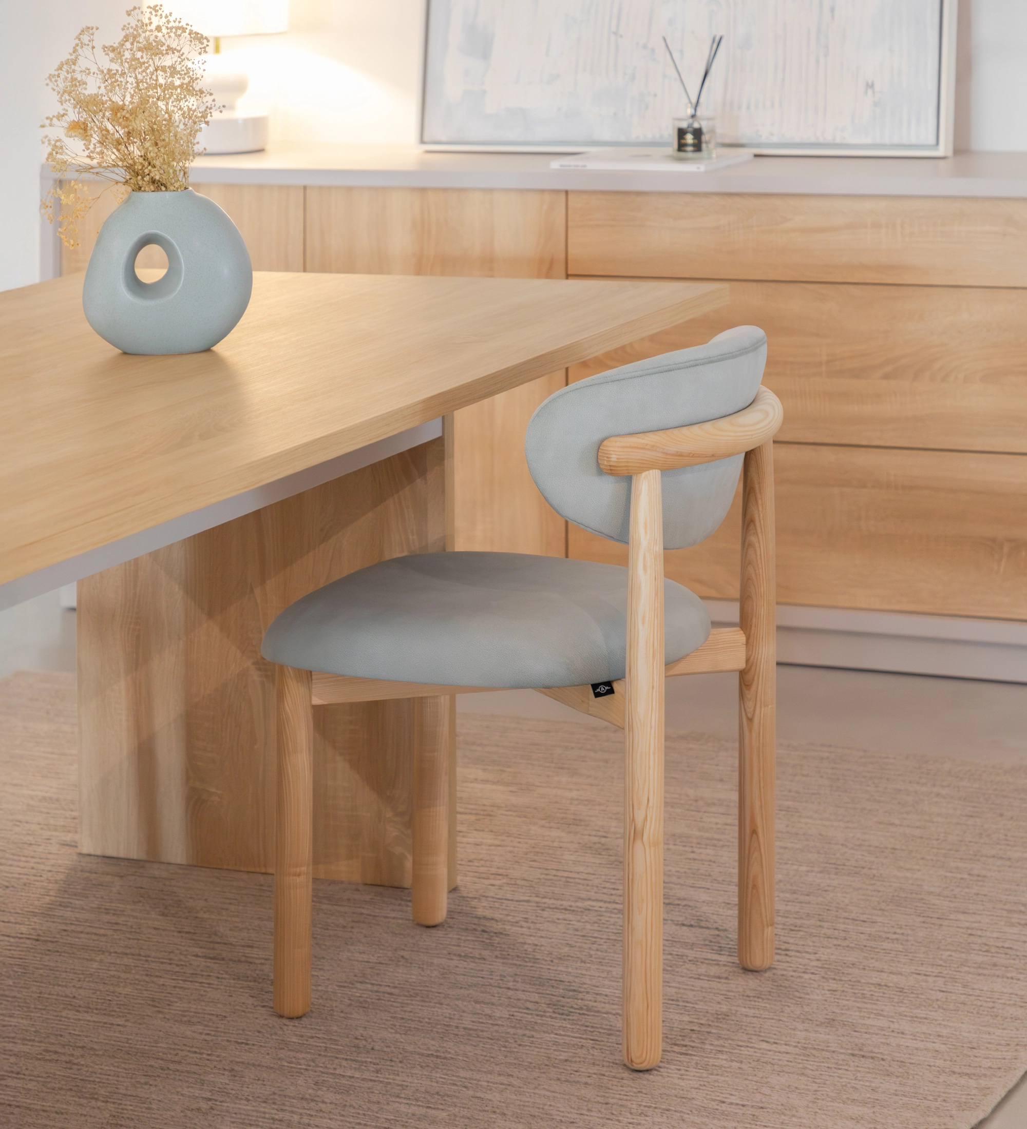 Cadeira Nice cinza claro com estrutura de madeira junto a mesa de madeira