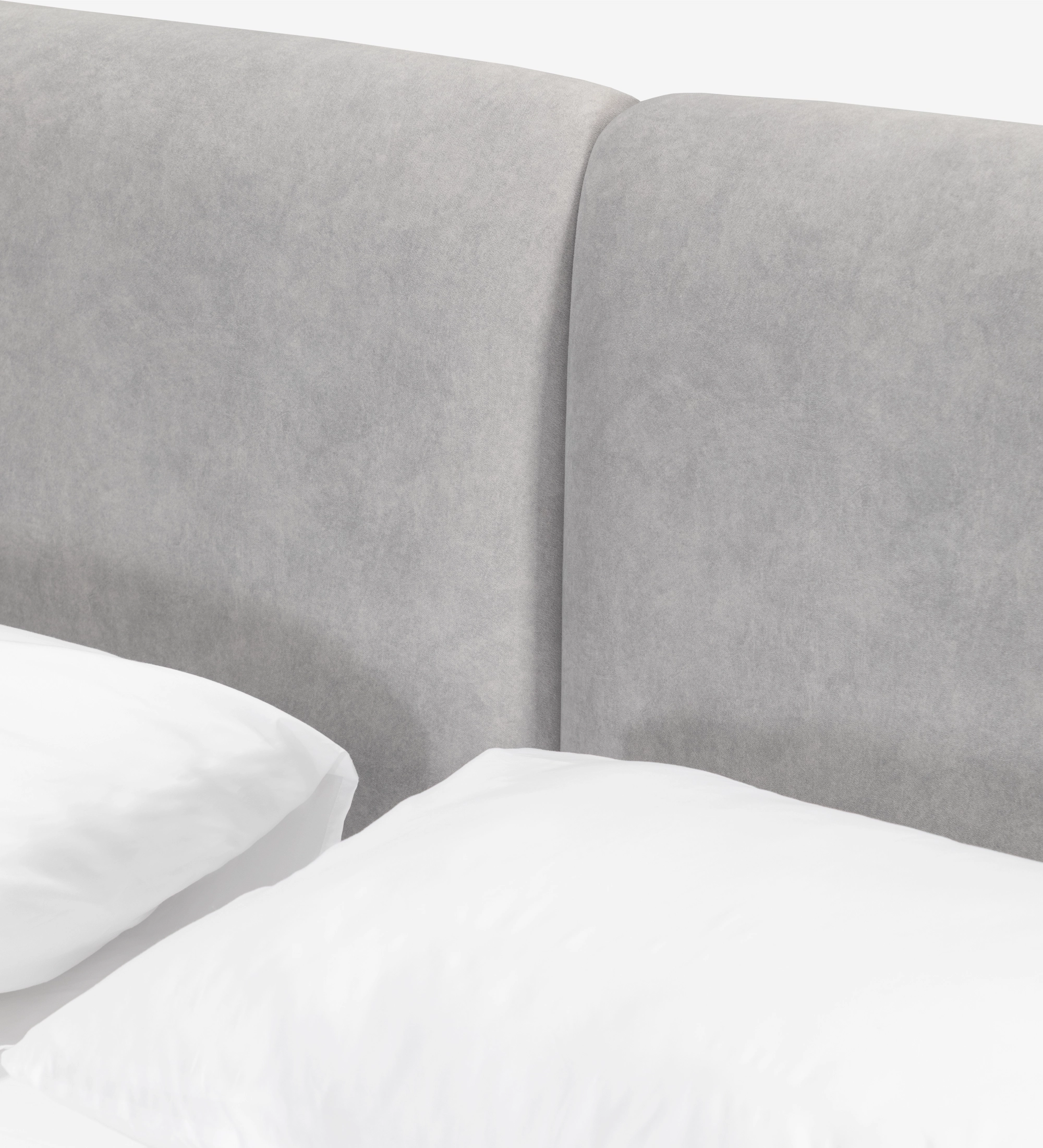 Cabecero tapizado gris claro de cama doble con almohadas blancas