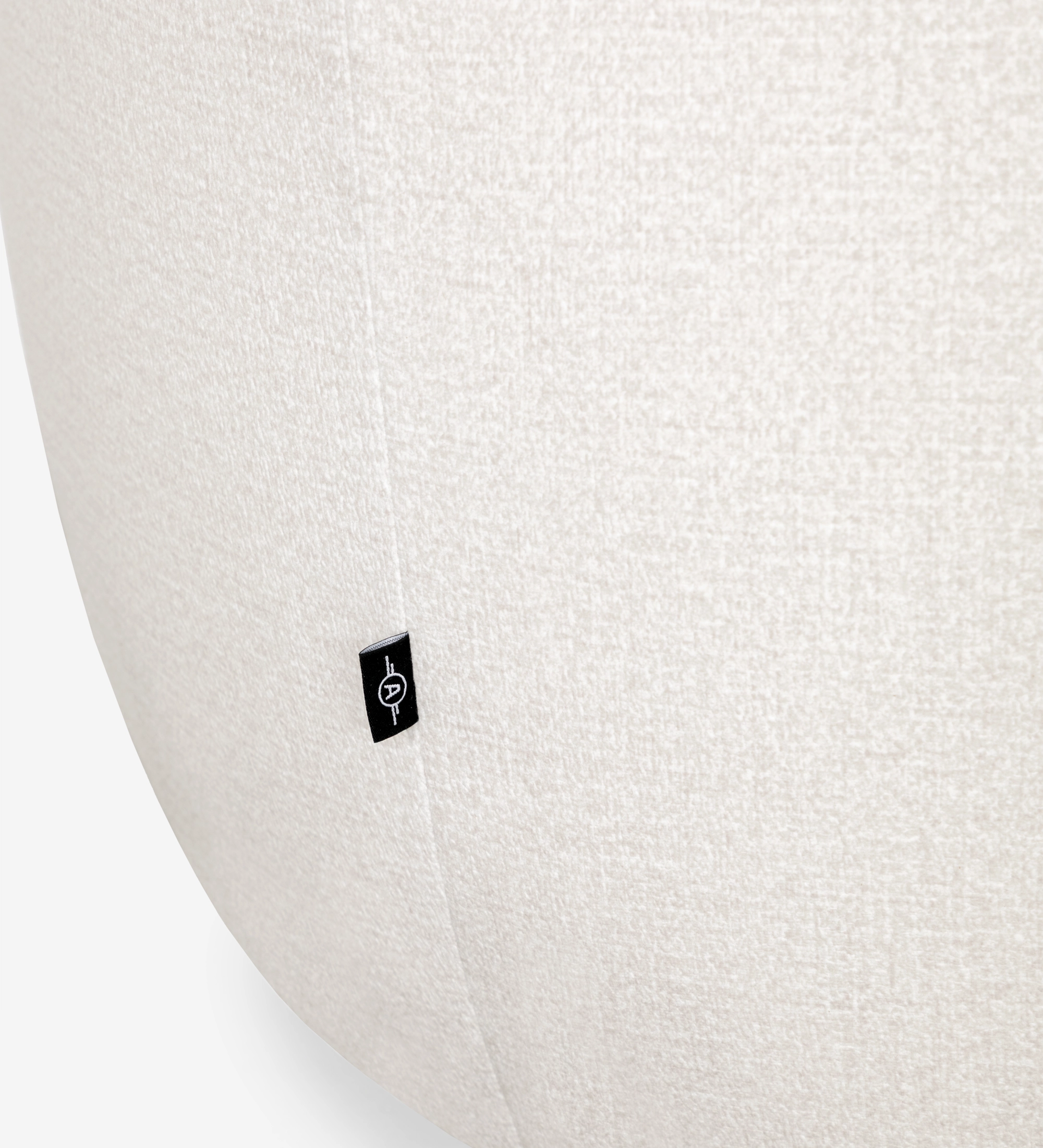 Sillón con base giratoria y completamente tapizado en tejido color perla.