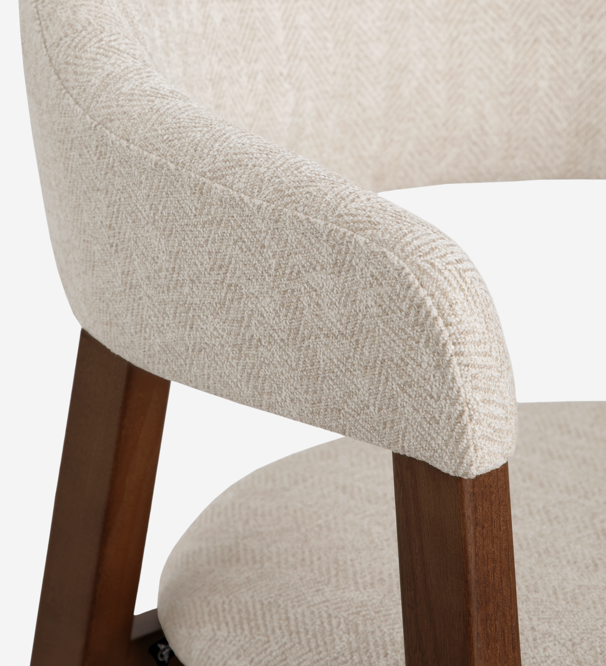 Silla con brazos, en madera de fresno color nogal, con asiento y respaldo tapizados en tela beige.