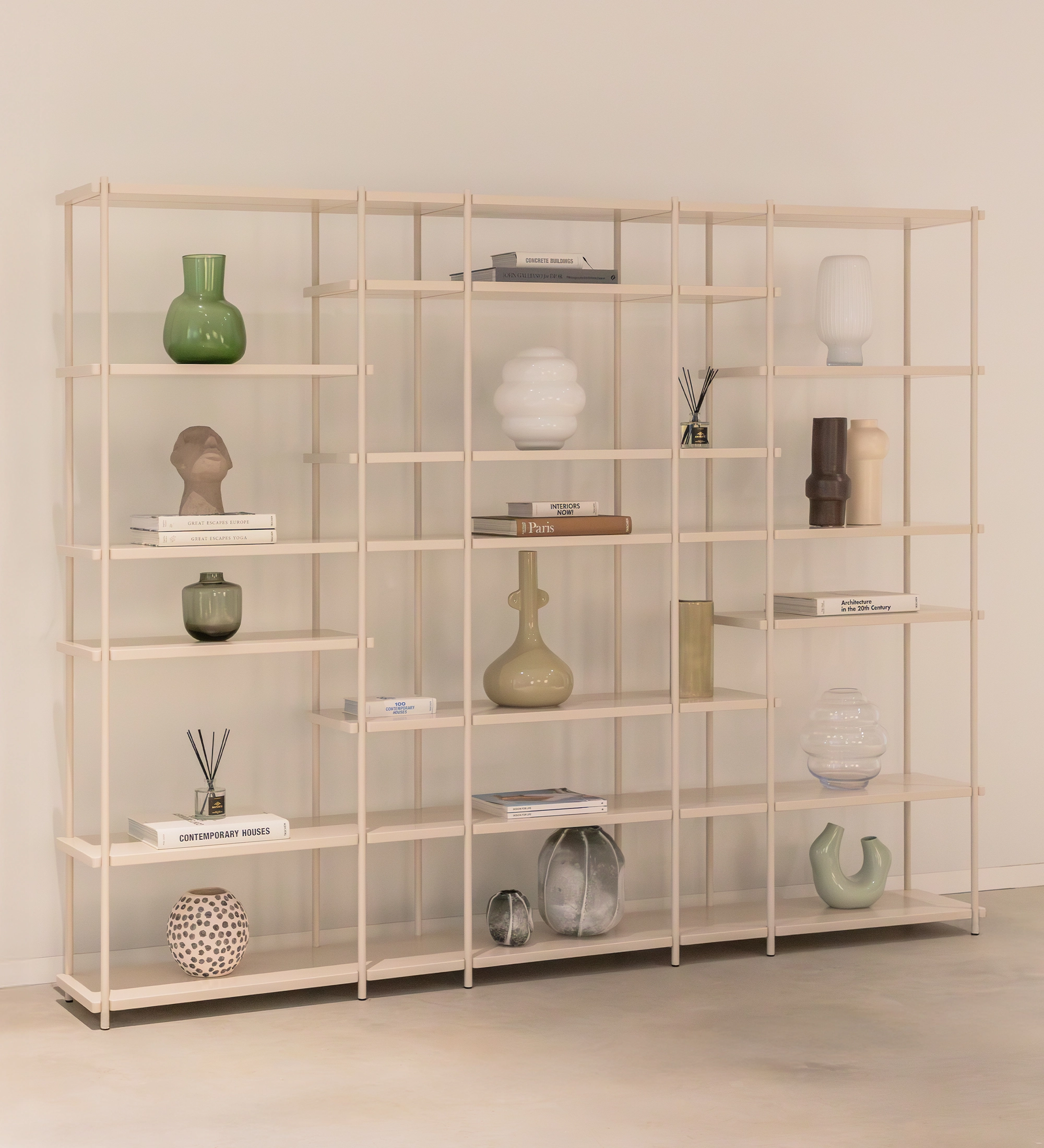 Estante Paris de madera clara con estantes abiertos y objetos decorativos minimalistas