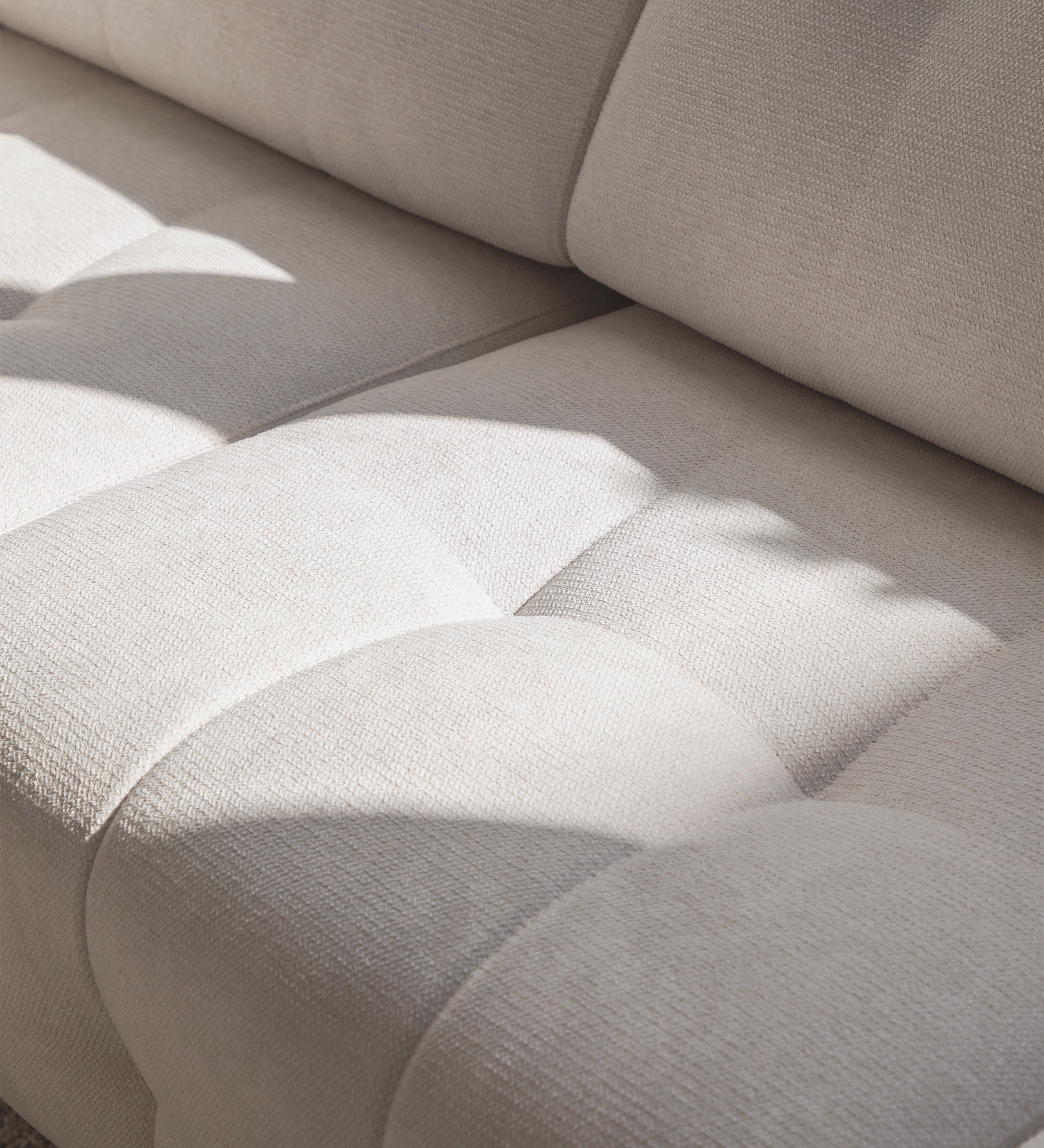 Sofá Madrid beige claro tapizado con capitoné y sombras suaves