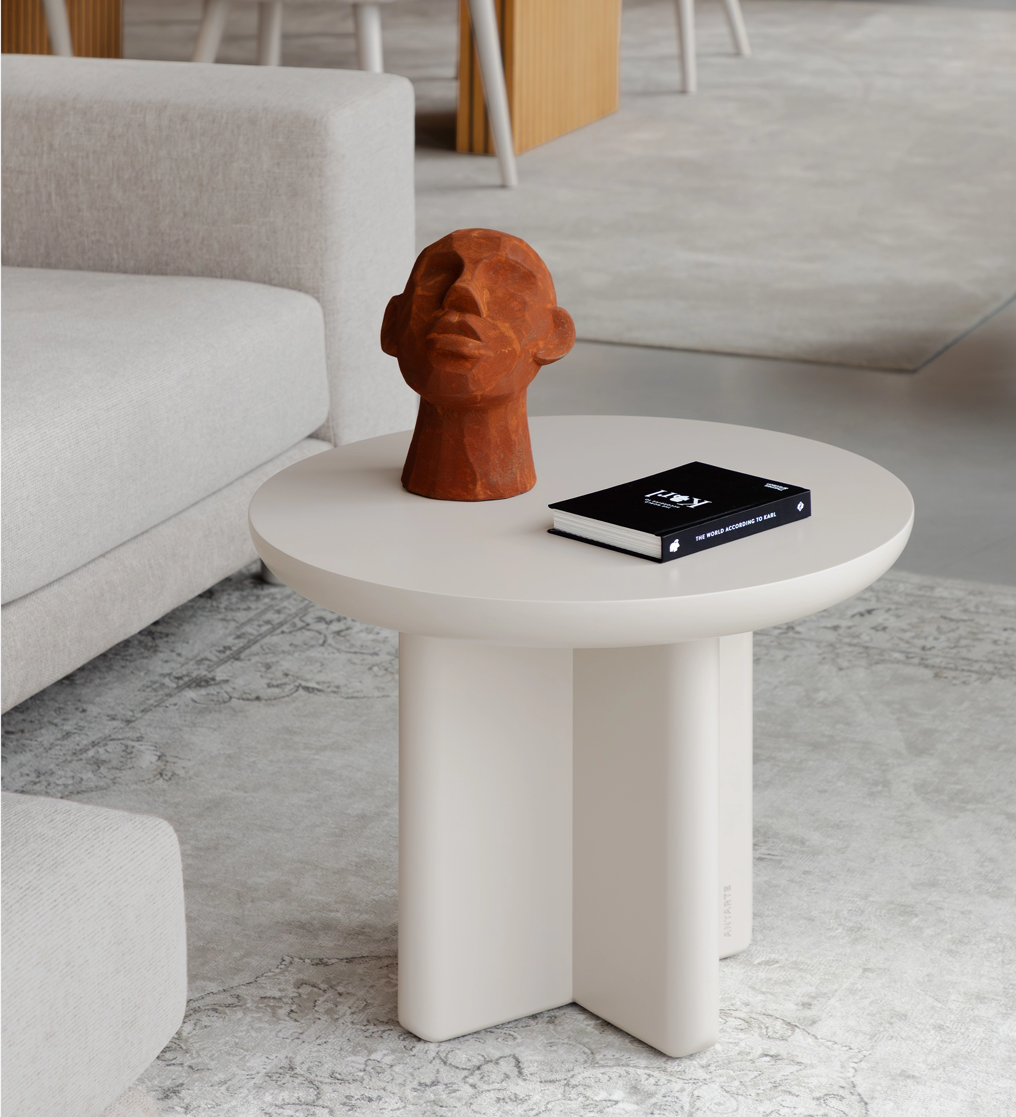 Table Basse Mónaco ronde blanche avec sculpture tête en terre cuite et livre noir