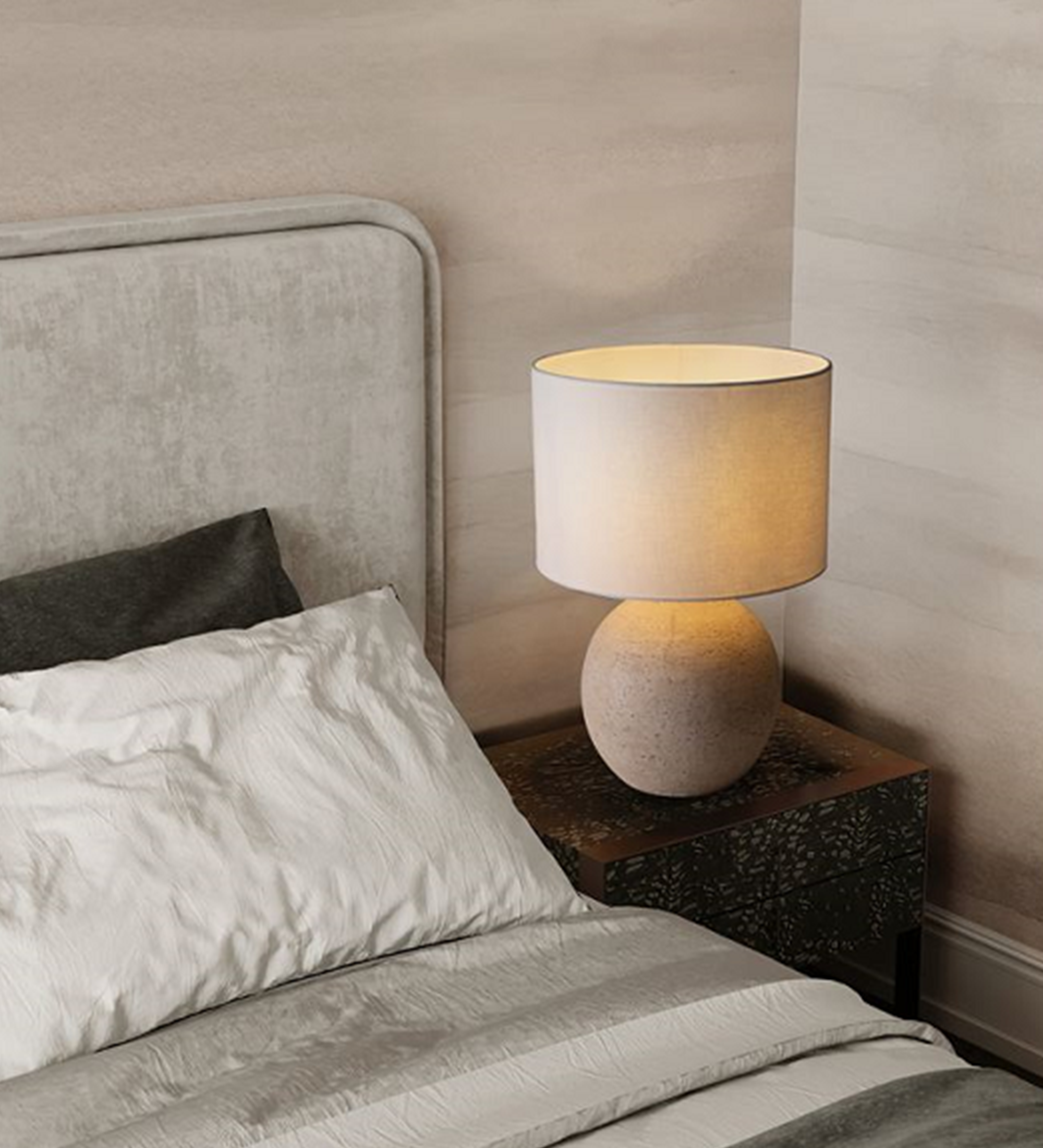 Candeeiro de Mesa Lagos com base esférica em pedra e abat-jour tecido ao lado da cama