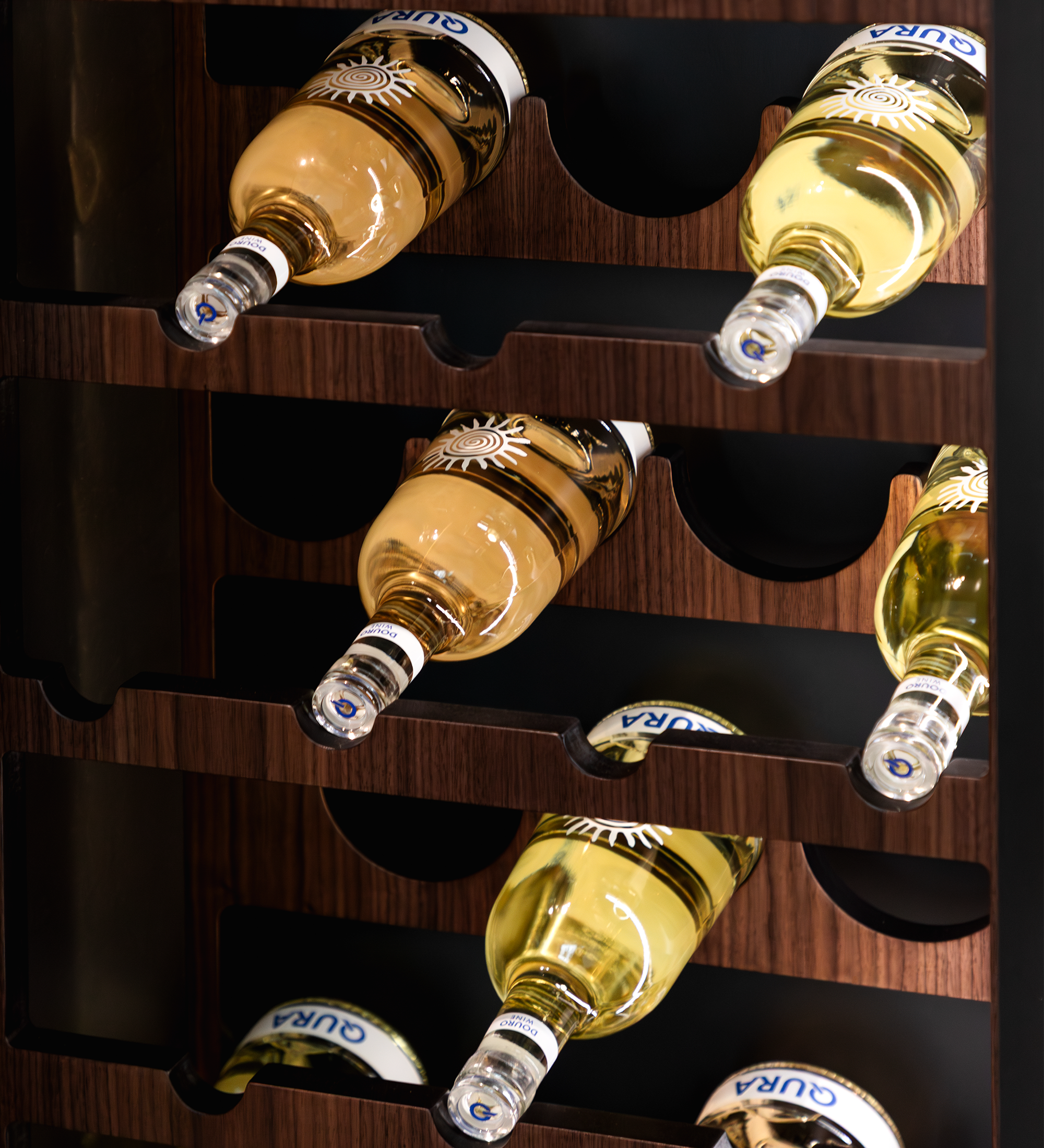 Vinoteca Cannes con botellas de vino blanco en estantes de madera