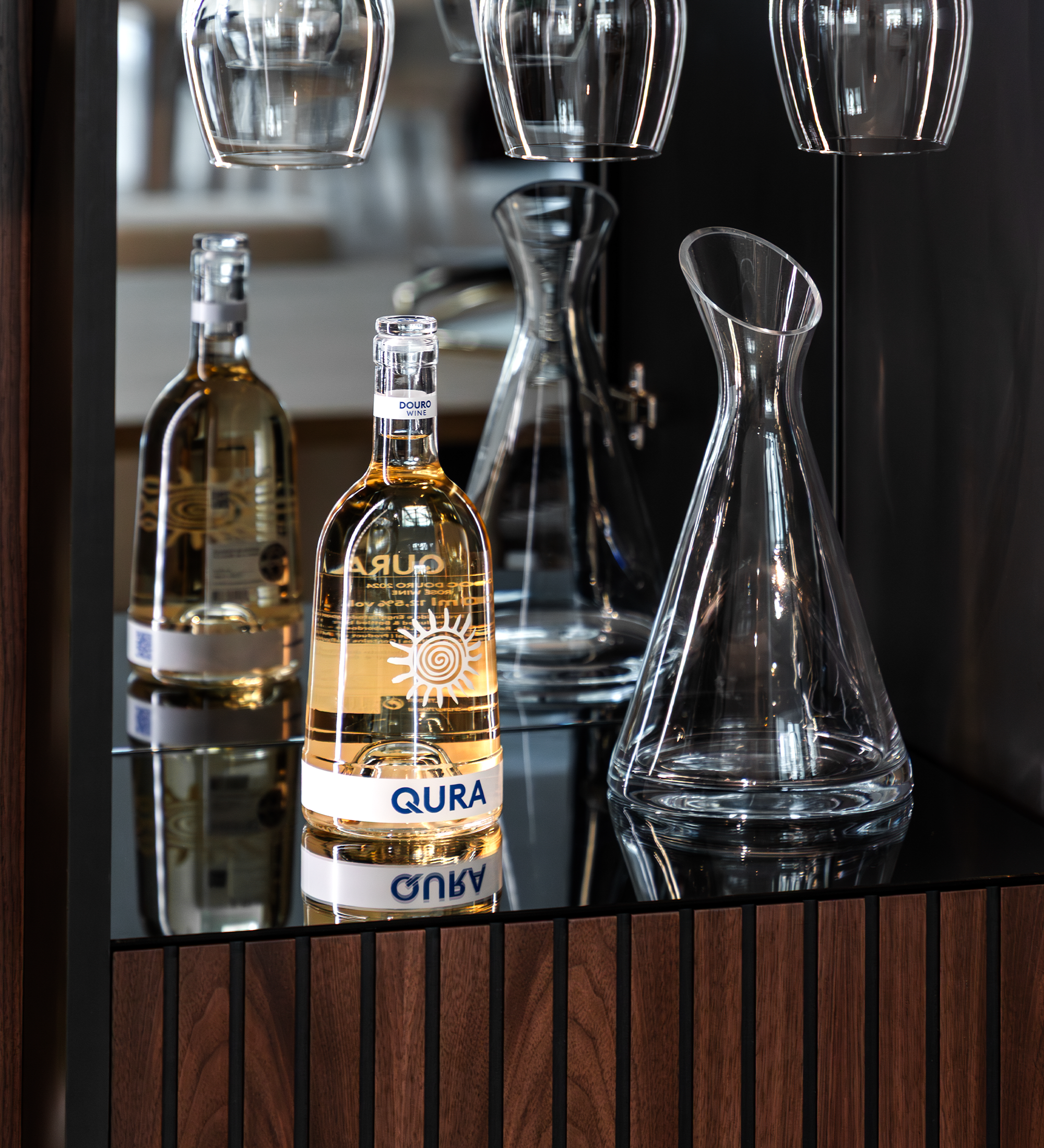 Vinoteca Cannes con botella de vino, decantador y copas sobre mueble de madera