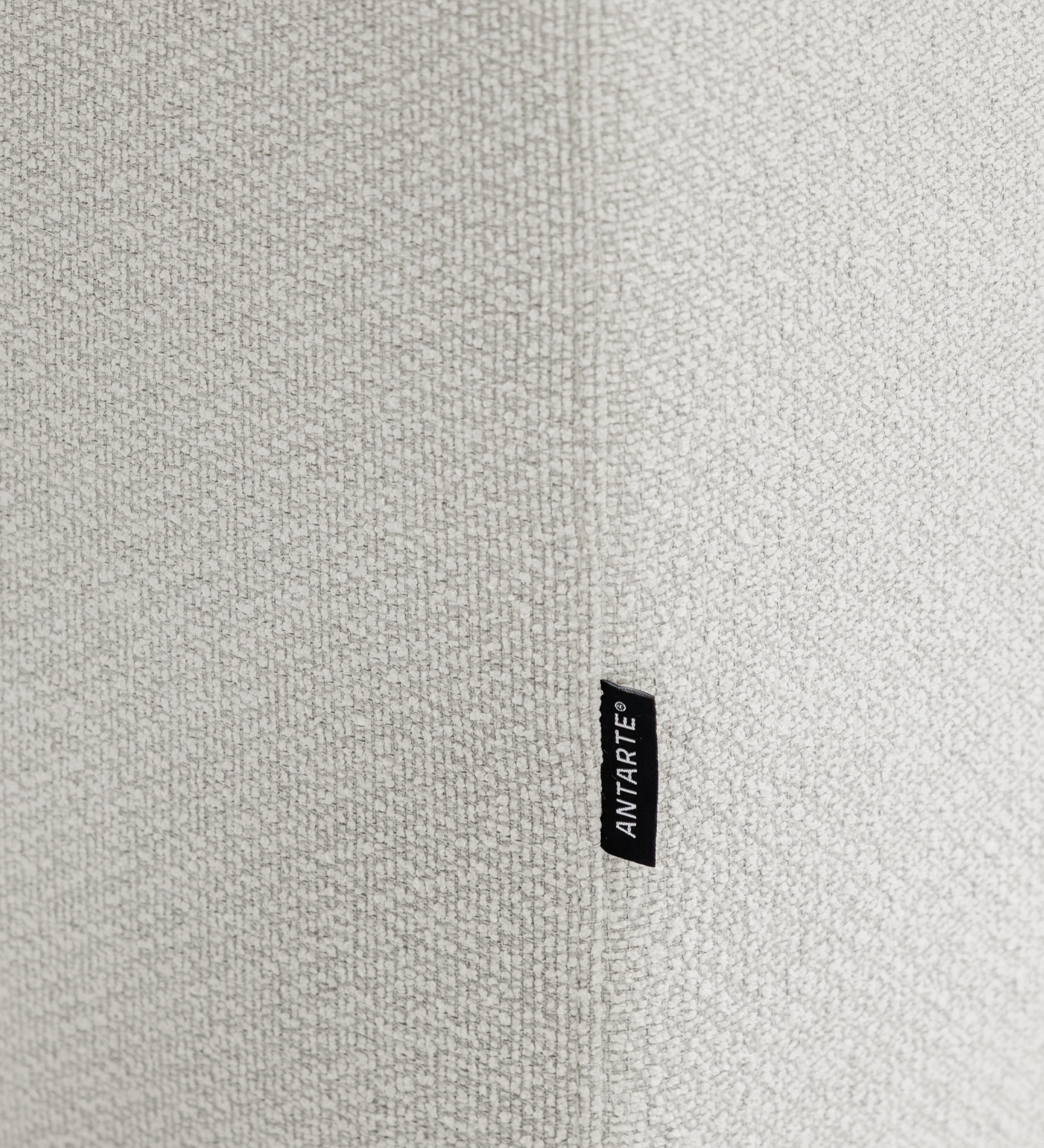 Sofá Lagos, primer plano de tejido bouclé beige con etiqueta negra