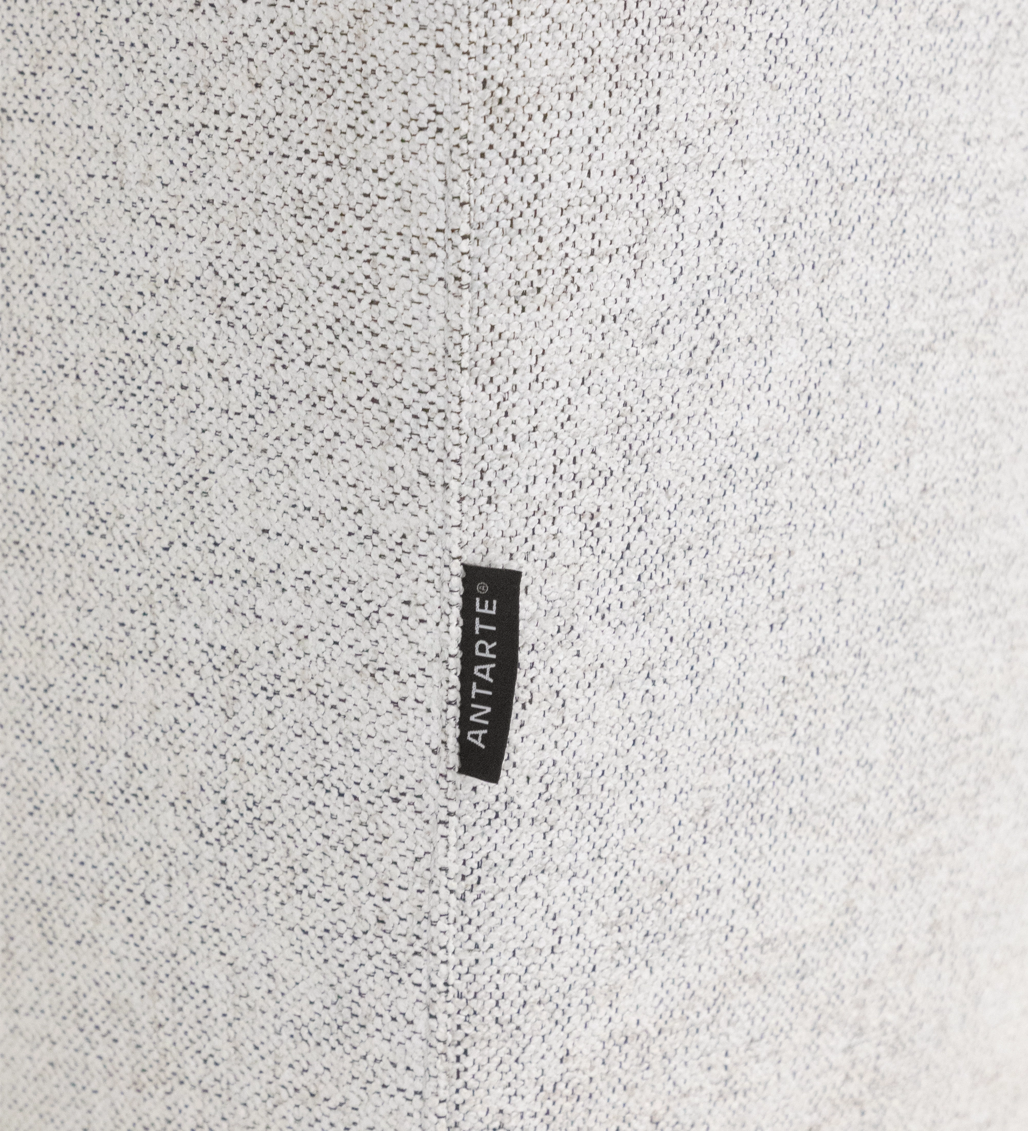 Close-up of Lagos Sofa with Chaise Longue beige textured upholstery with black ANTARTE label