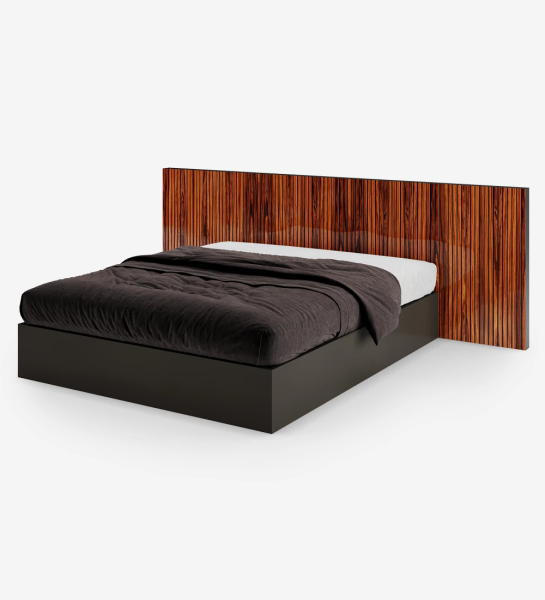 Lit double avec tête de lit avec frises en palissandro brillance et sommier noir, avec rangement via un lit surélevé.